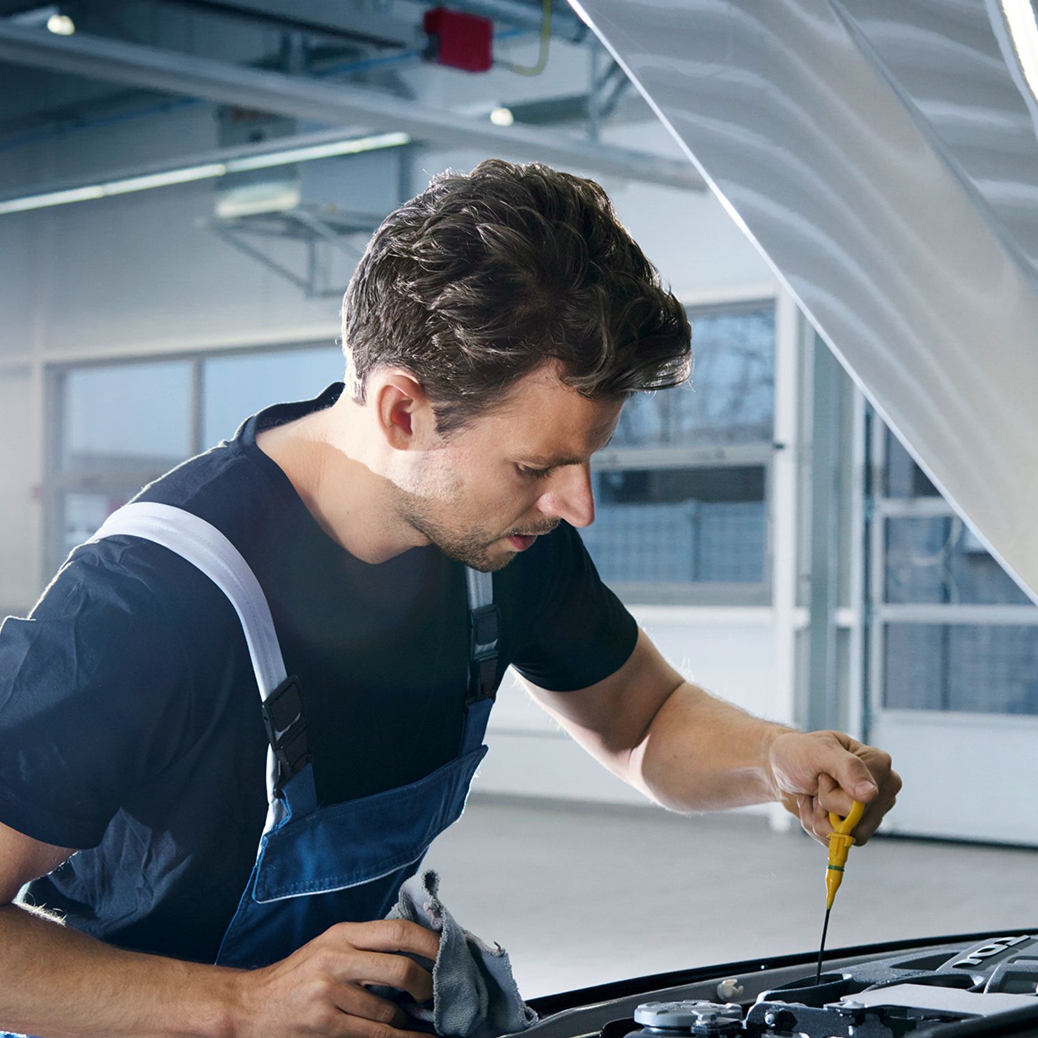 Механик проверява нивото на маслото в сервиз на Volkswagen