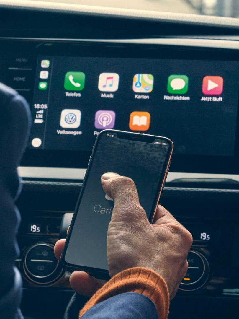Ein Mann bedient gerade die VW We Connect App auf einem Smartphone