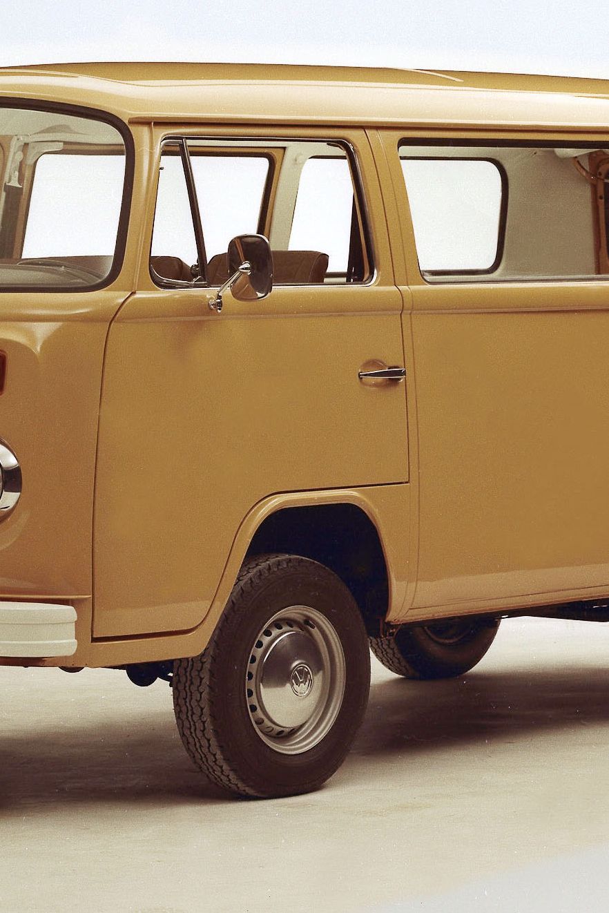 Ретро микробус Volkswagen с бяла броня и две врати отстрани. Микробусът е сниман на светъл фон. Той е модел от около 70-те години.