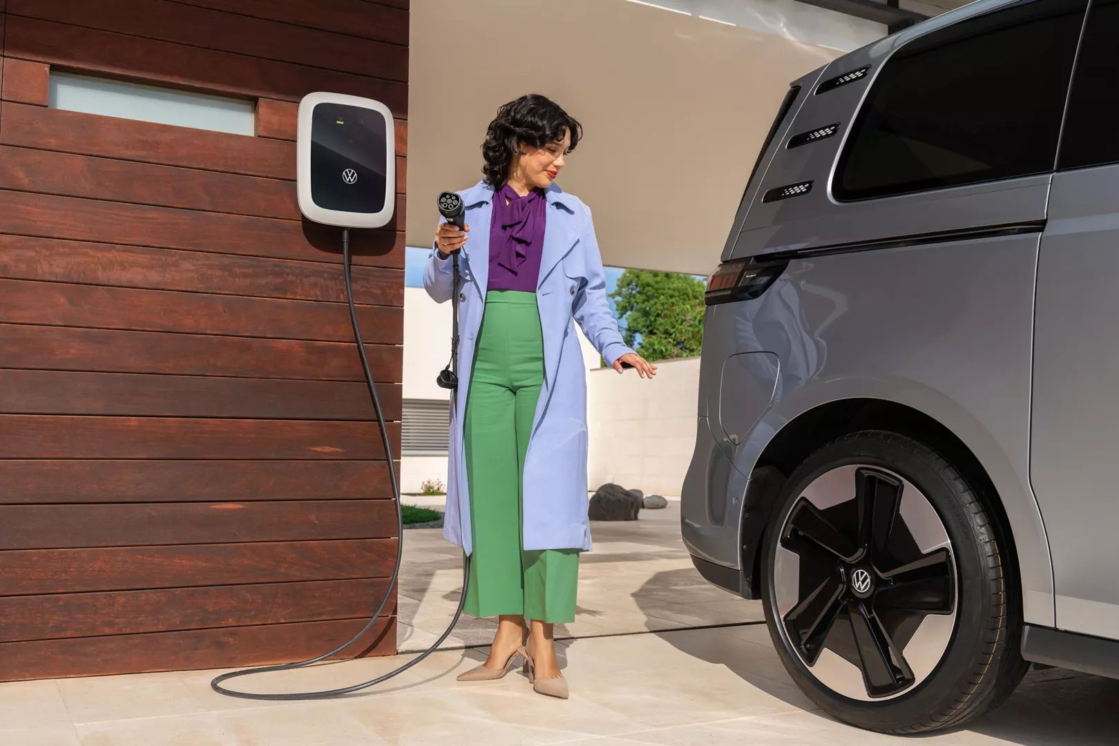 Жена зарежда електрическия Volkswagen ID. Buzz у дома