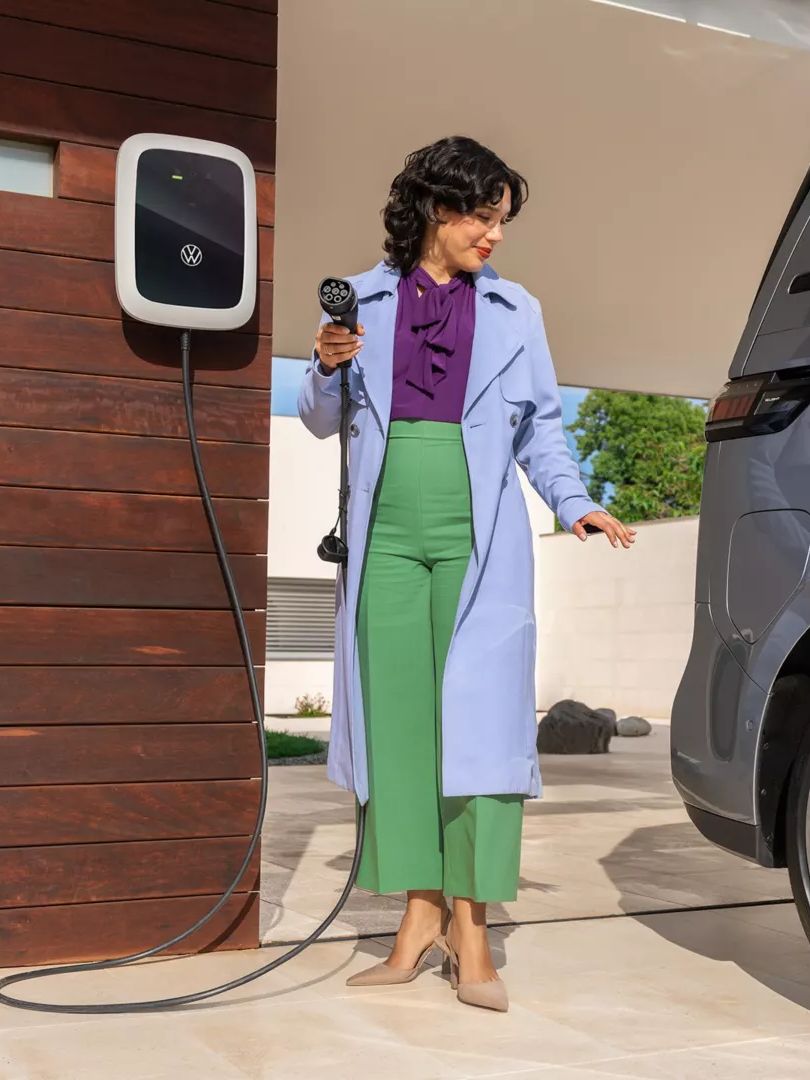 Жена зарежда електрическия Volkswagen ID. Buzz у дома
