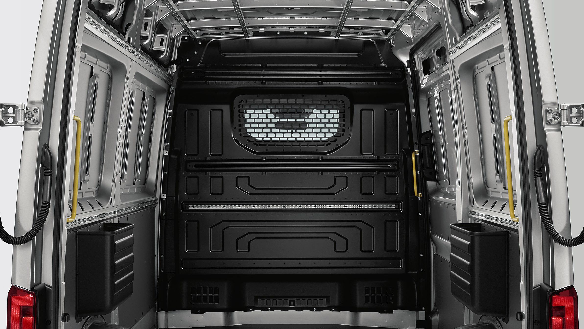 Изглед в товарното отделение на Volkswagen лекотоварен автомобил Crafter Товарен вариант. Отвътре се вижда преградна стена с прозорец и защитна решетка.