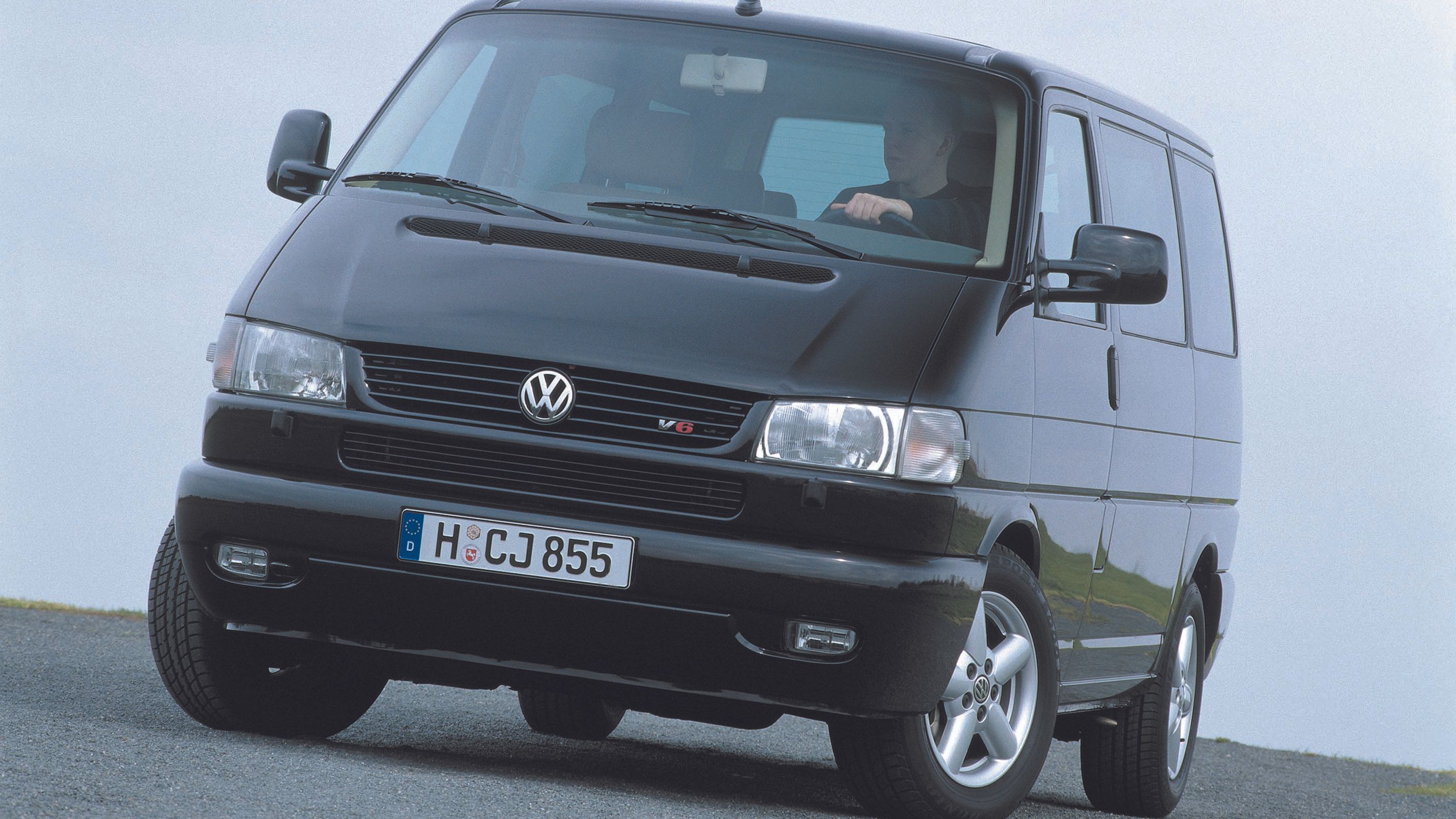 Черен Volkswagen Transporter T4 с V6 двигател, заснет в движение на път с лек наклон