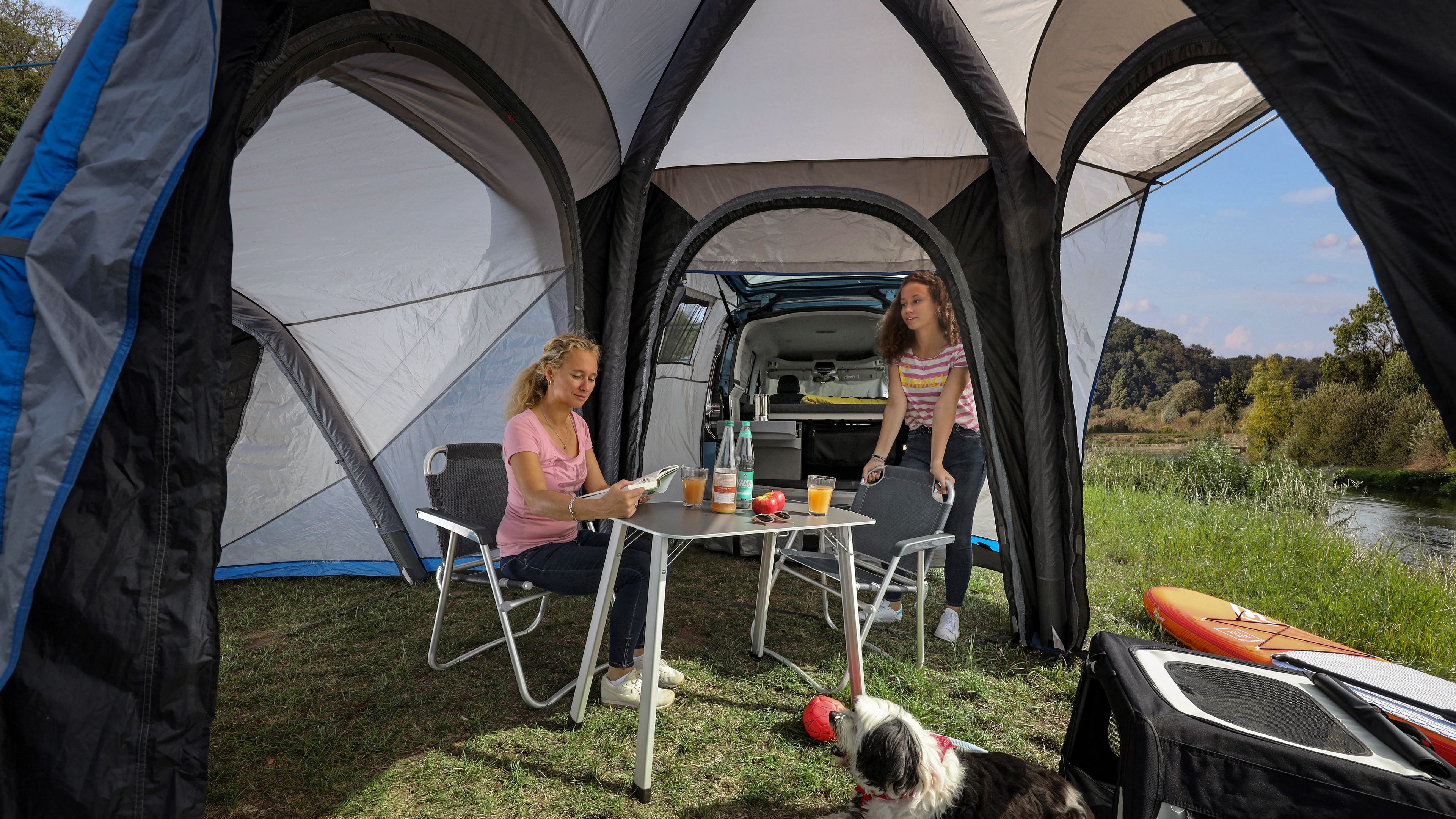 Frauen und Hund sitzen unter Zelt von Caddy California.