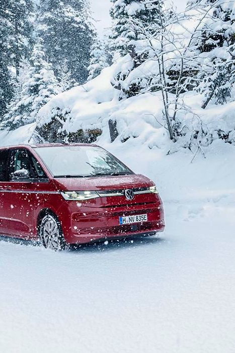 Multivan в червен цвят сред снежна гора