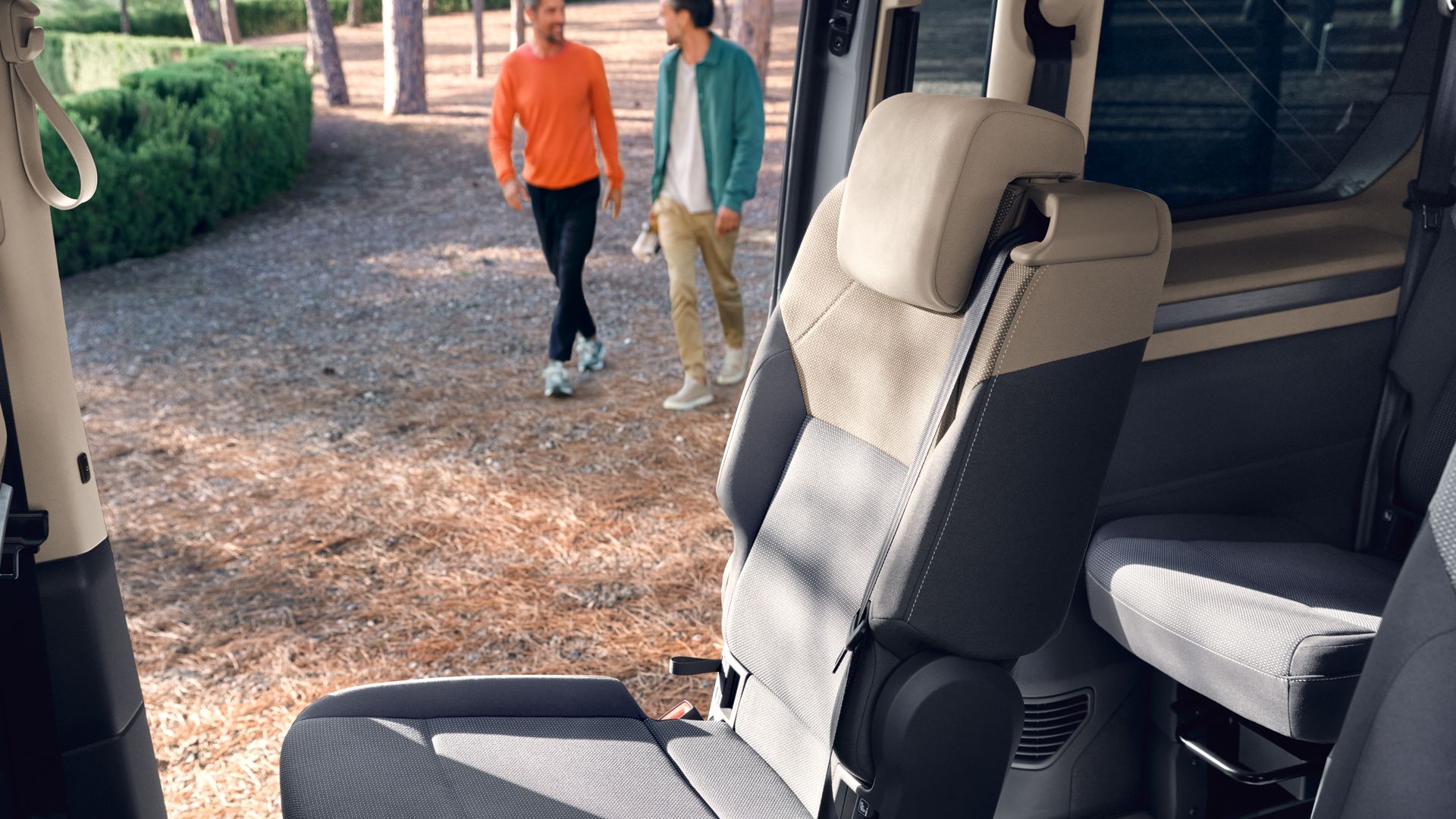 Ein Einzelsitz wird im neuen VW Multivan Life T7 2021 durch die offene Schiebetür von der Sonne angestrahlt.