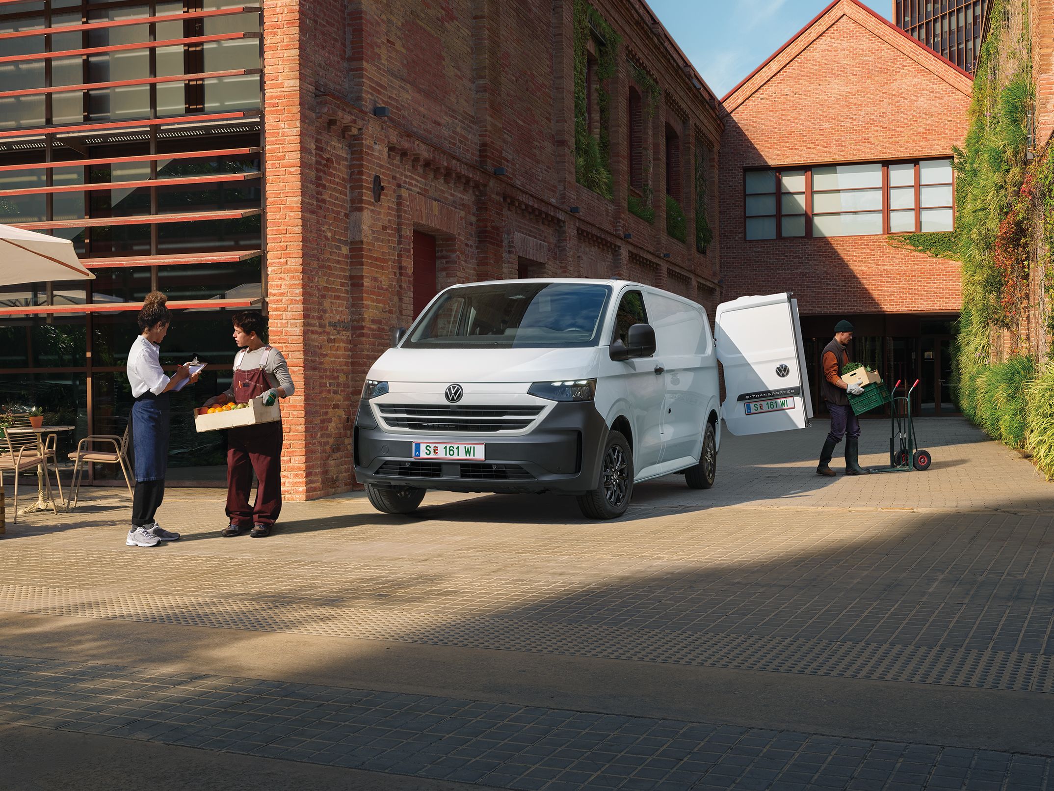 Volkswagen Transporter доставя продукти пред ресторант, докато служители приемат пратката.