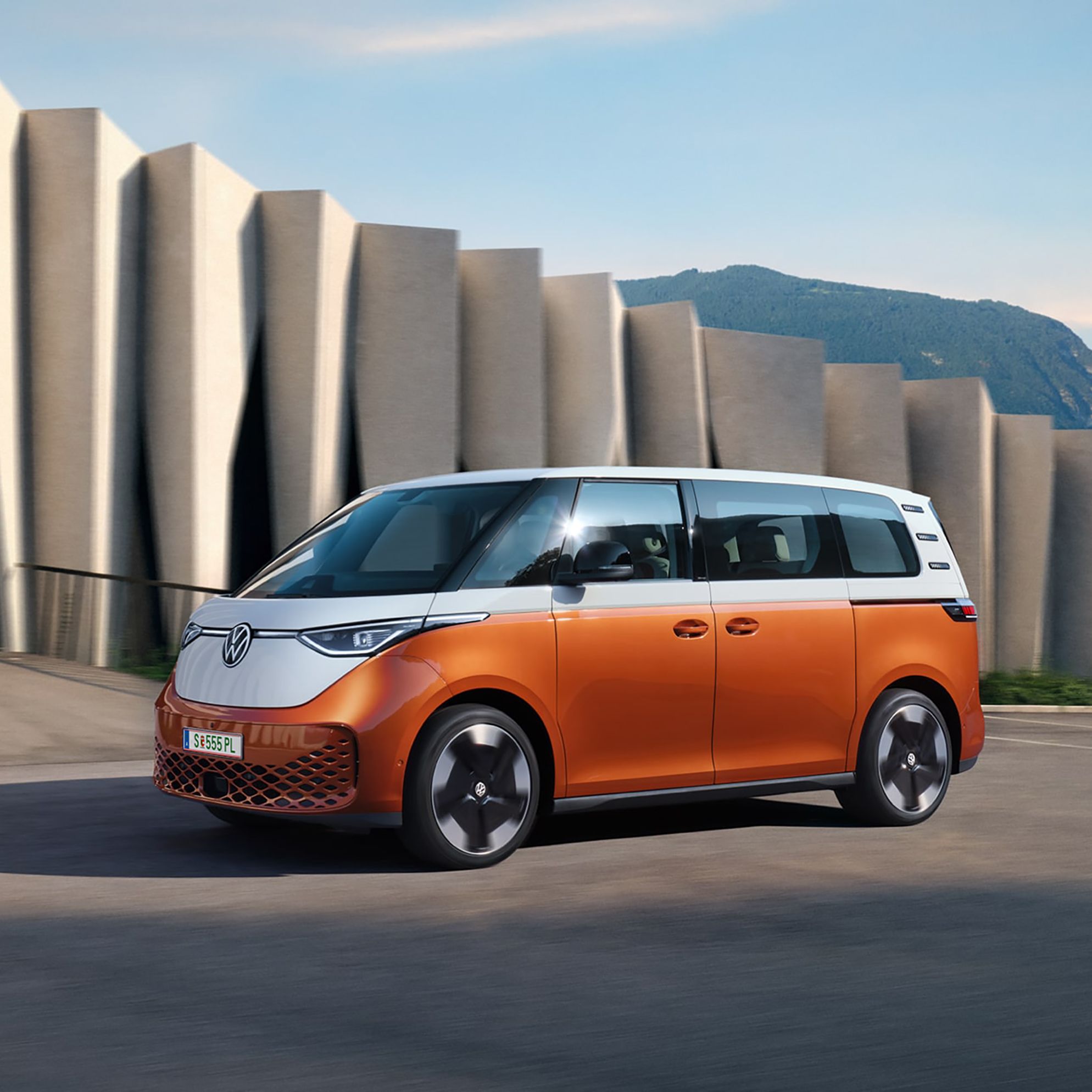 Volkswagen ID. Buzz в движение пред модерна архитектура и планински фон