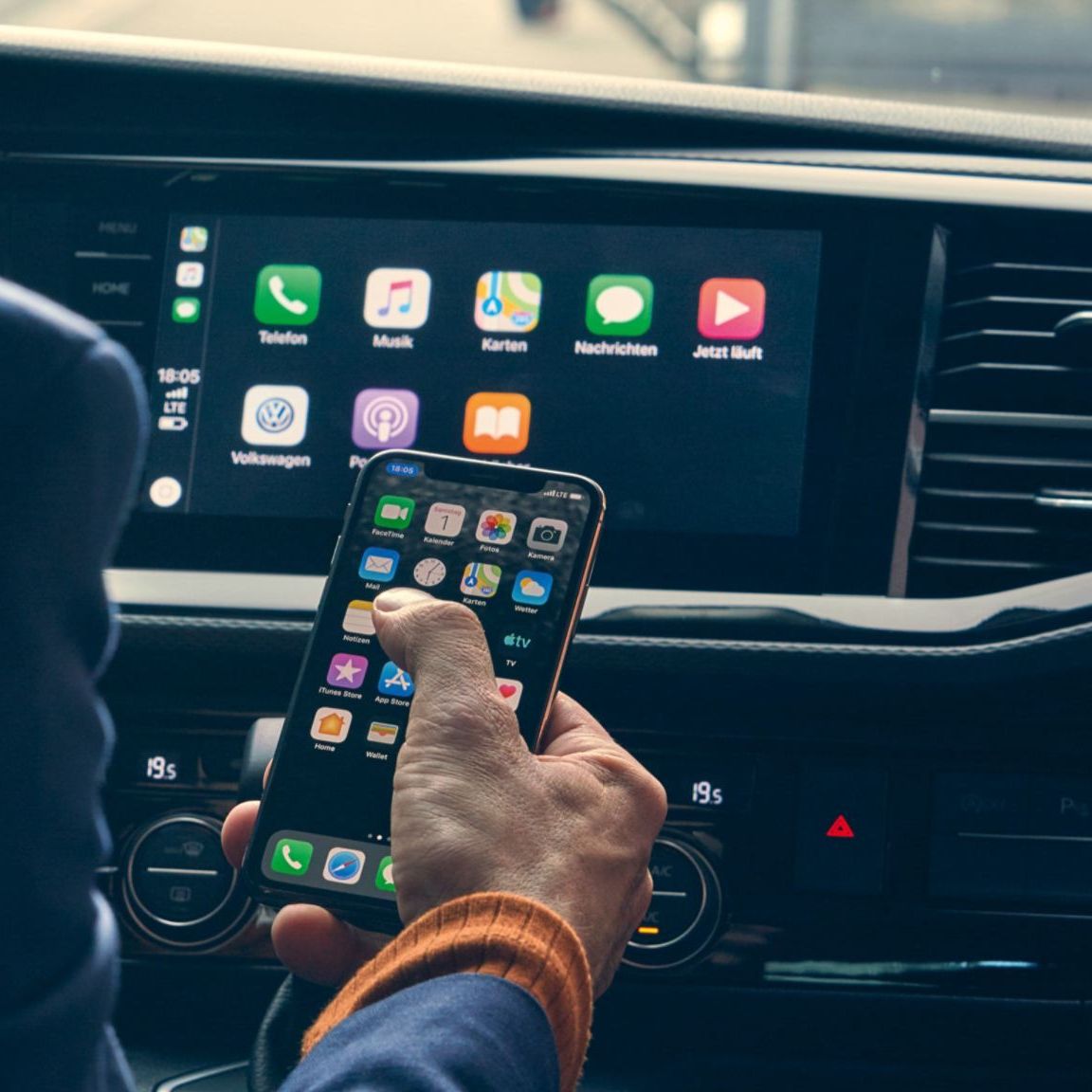 Водач свързва смартфон с Apple CarPlay в мултимедийната система на автомобил Volkswagen.