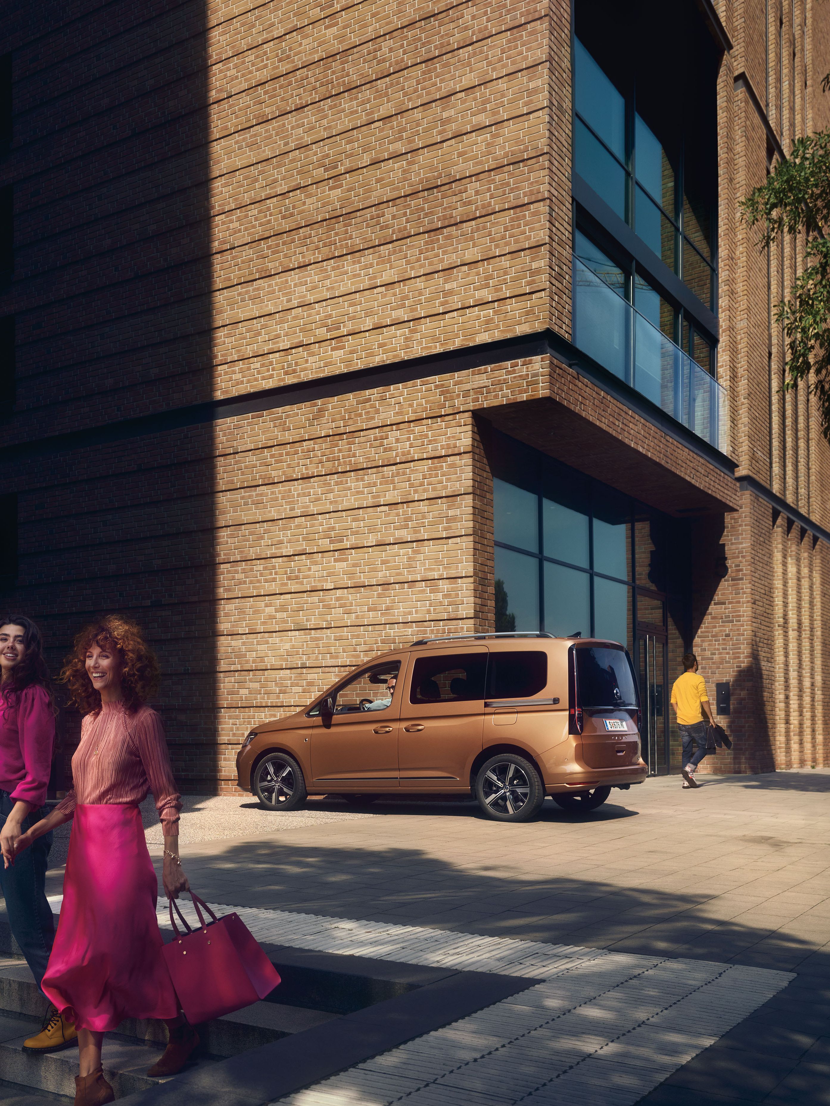 Майка и дъщеря слизат по стълбите, зад тях се вижда VW Caddy.
