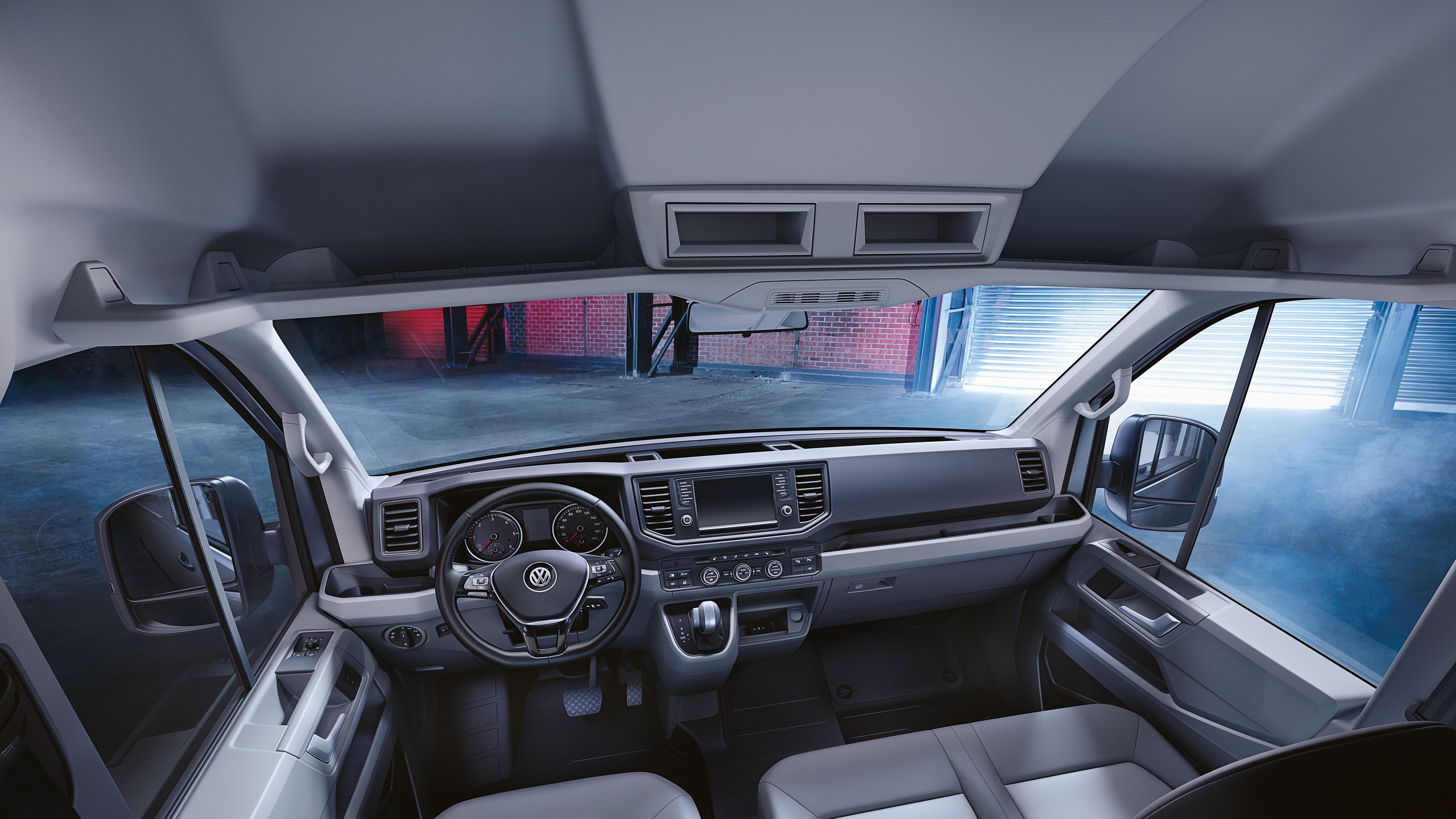 Поглед в кабината на водача на Volkswagen лекотоварен автомобил Crafter с многобройни отделения и поставки за вещи.