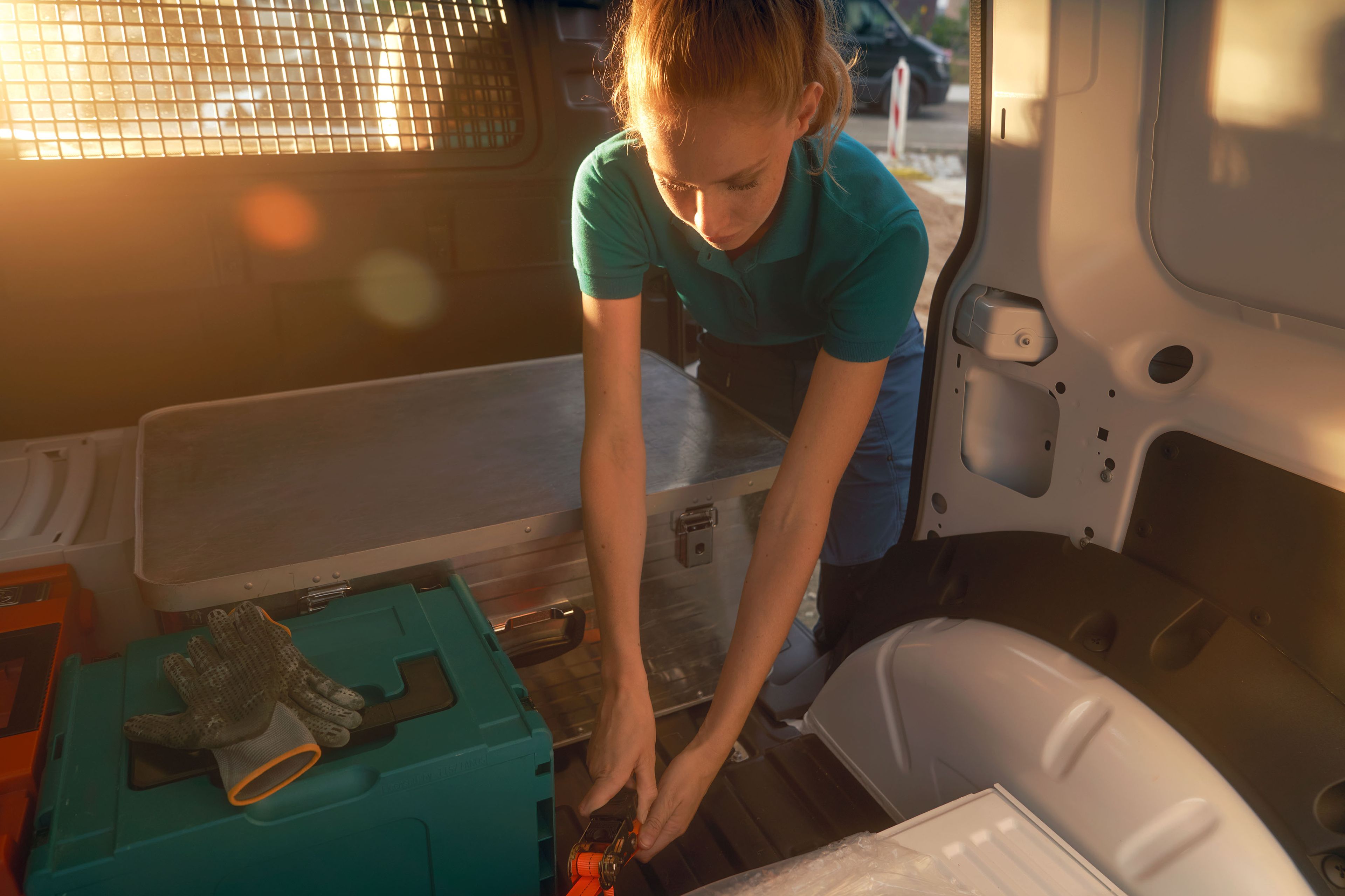 Жена по време на товарене на бял VW Caddy Cargo.