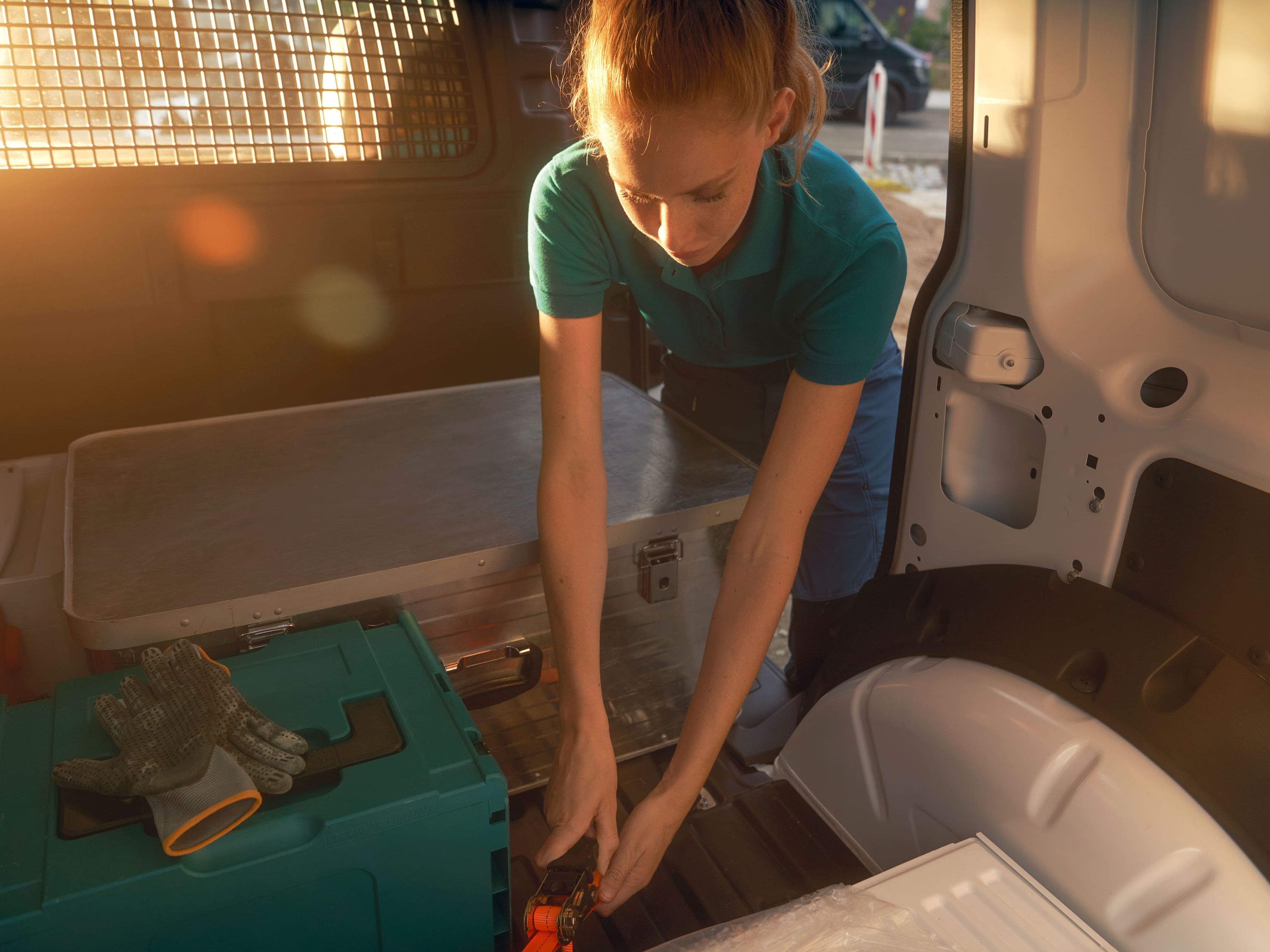 Жена по време на товарене на бял VW Caddy Cargo.