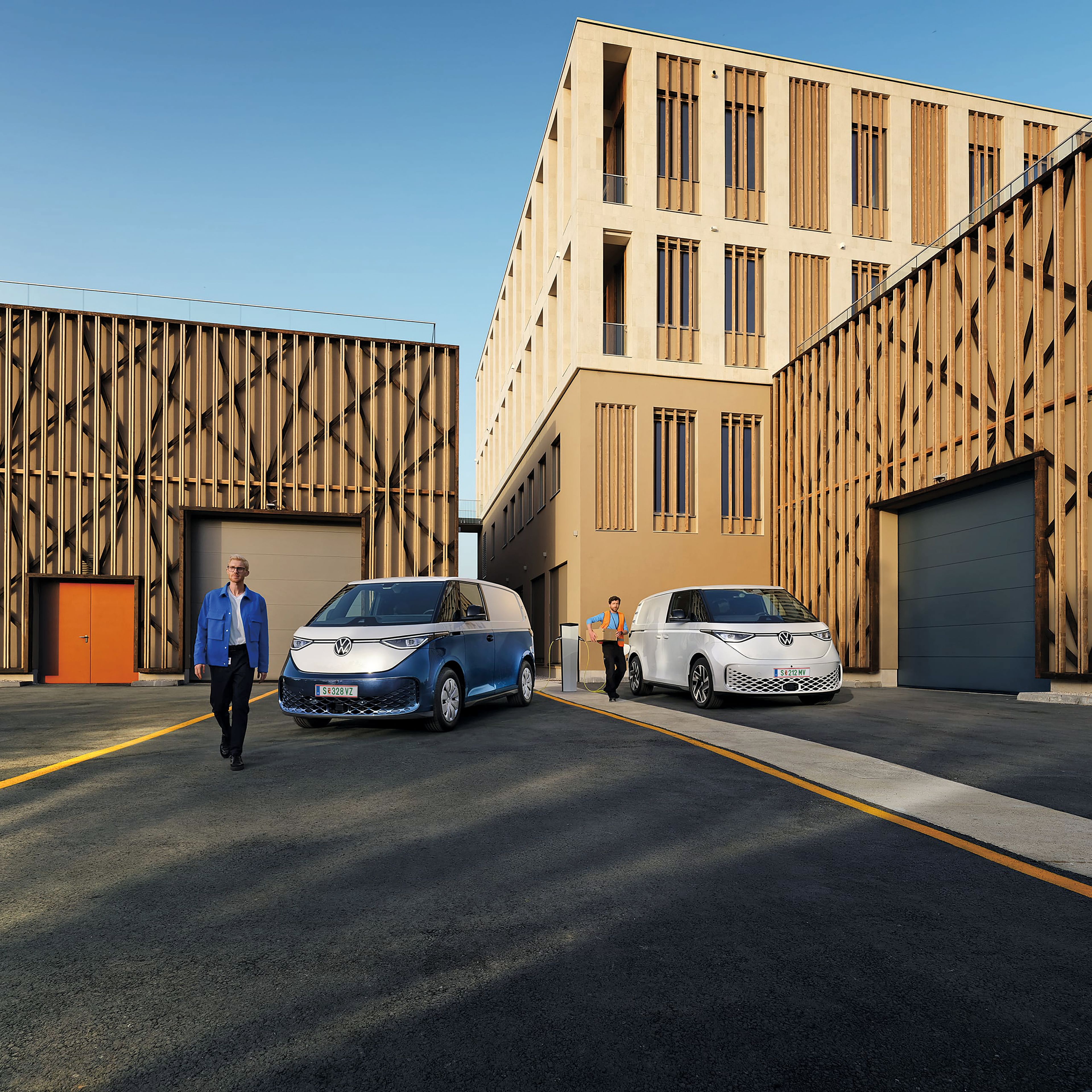 Два електрически товарни микробуса Volkswagen ID. Buzz Cargo пред модерна офис сграда