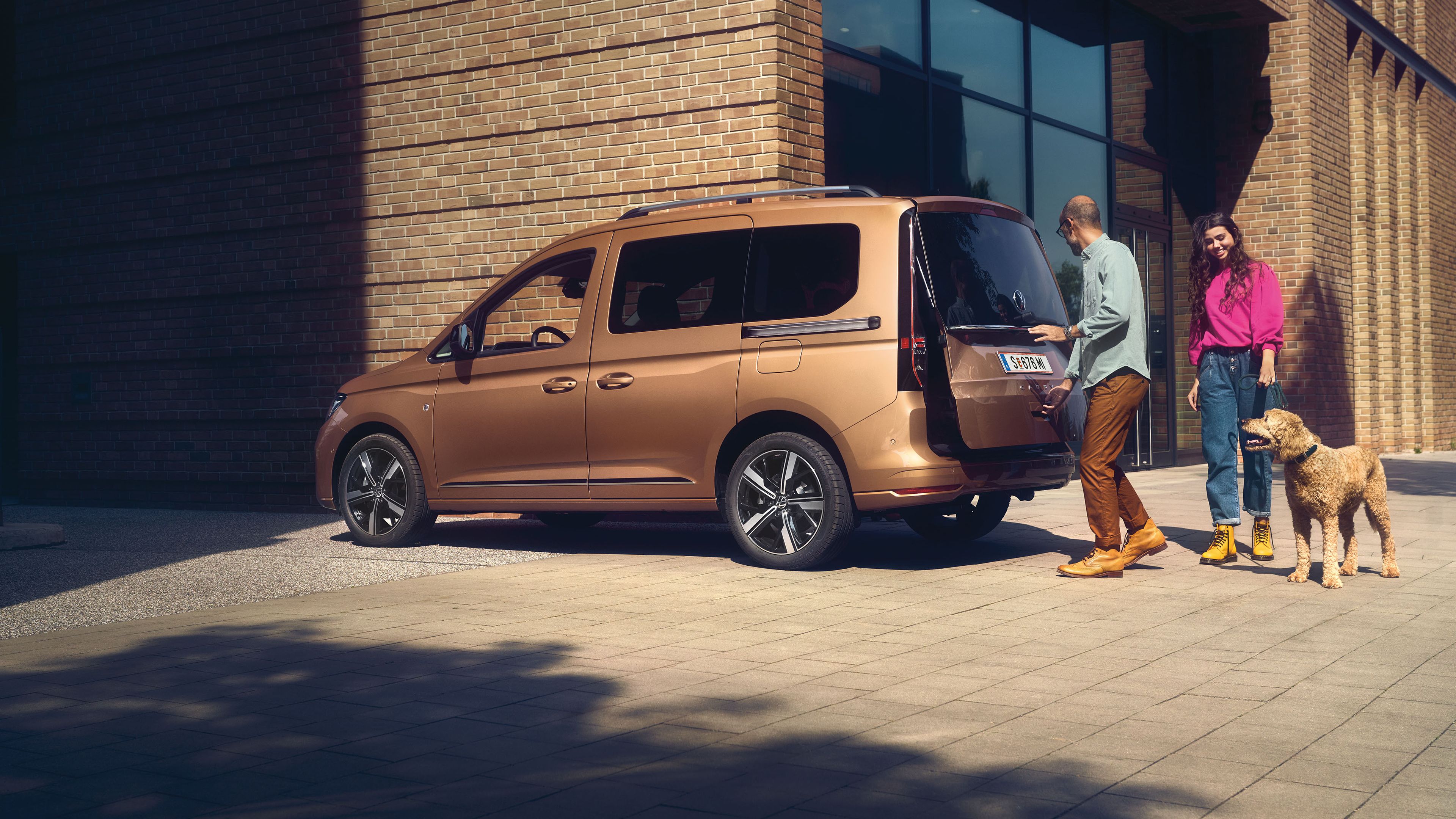 Мъж отваря задната врата с остъкляване на VW Caddy.