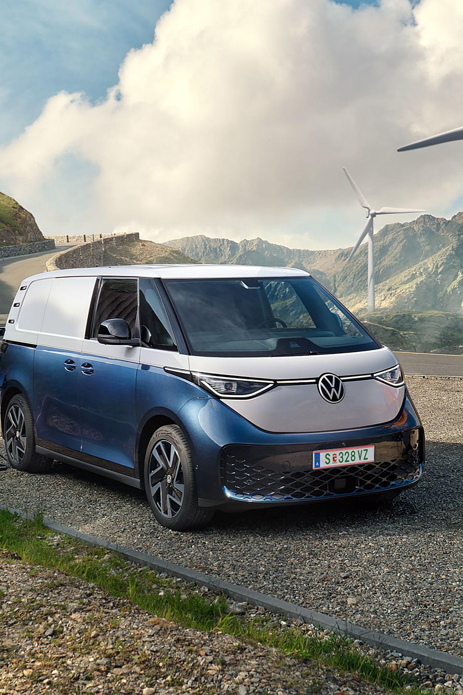 Volkswagen ID. Buzz Cargo в процес на зареждане сред вятърни турбини и планински пейзаж