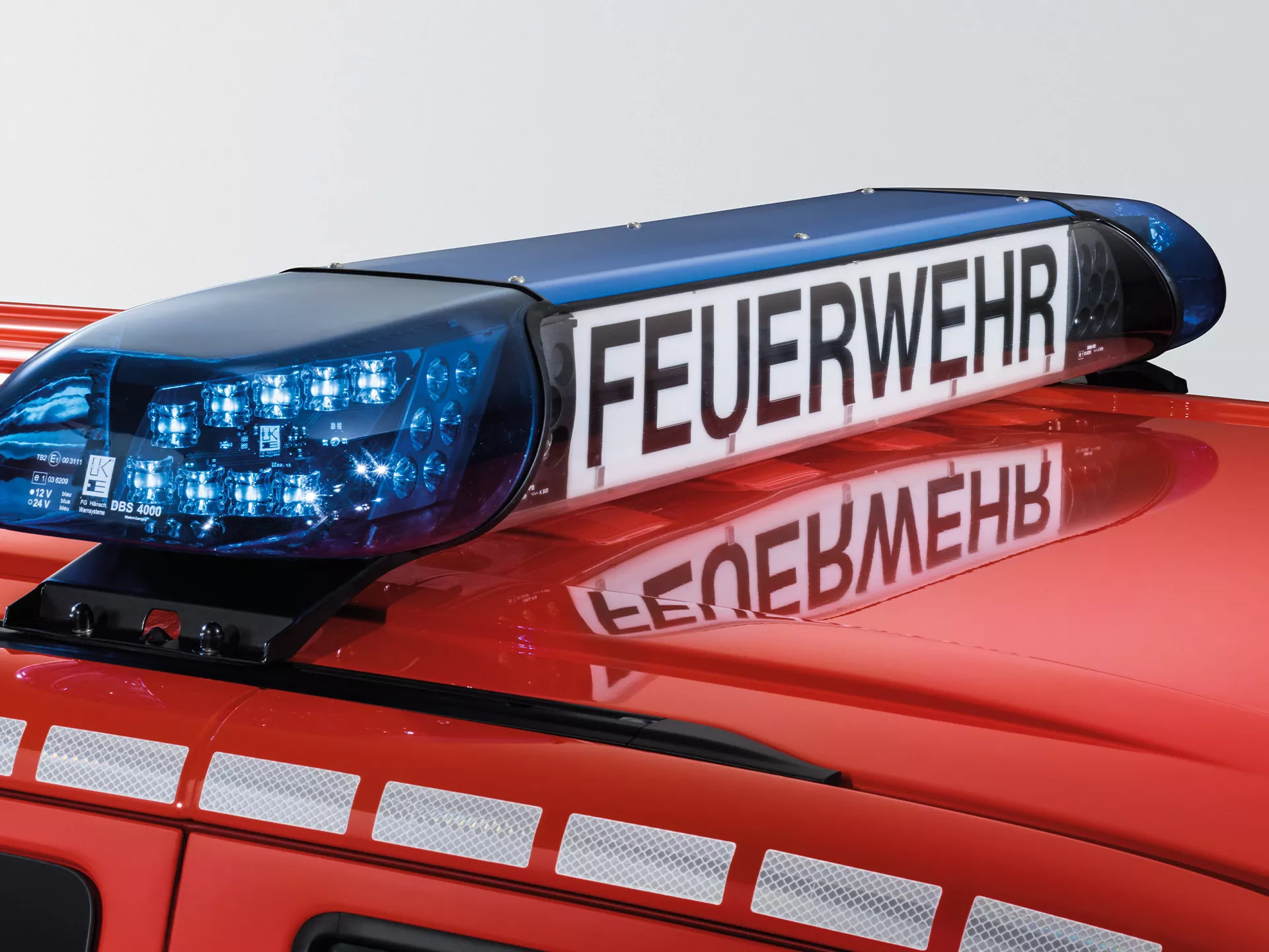 Светлинен сигнал с надпис 'FEUERWEHR' върху покрива на пожарен автомобил Volkswagen
