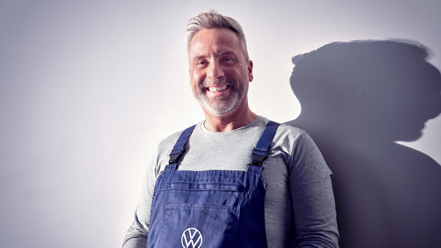Ein Volkswagen Techniker lacht in die Kamera