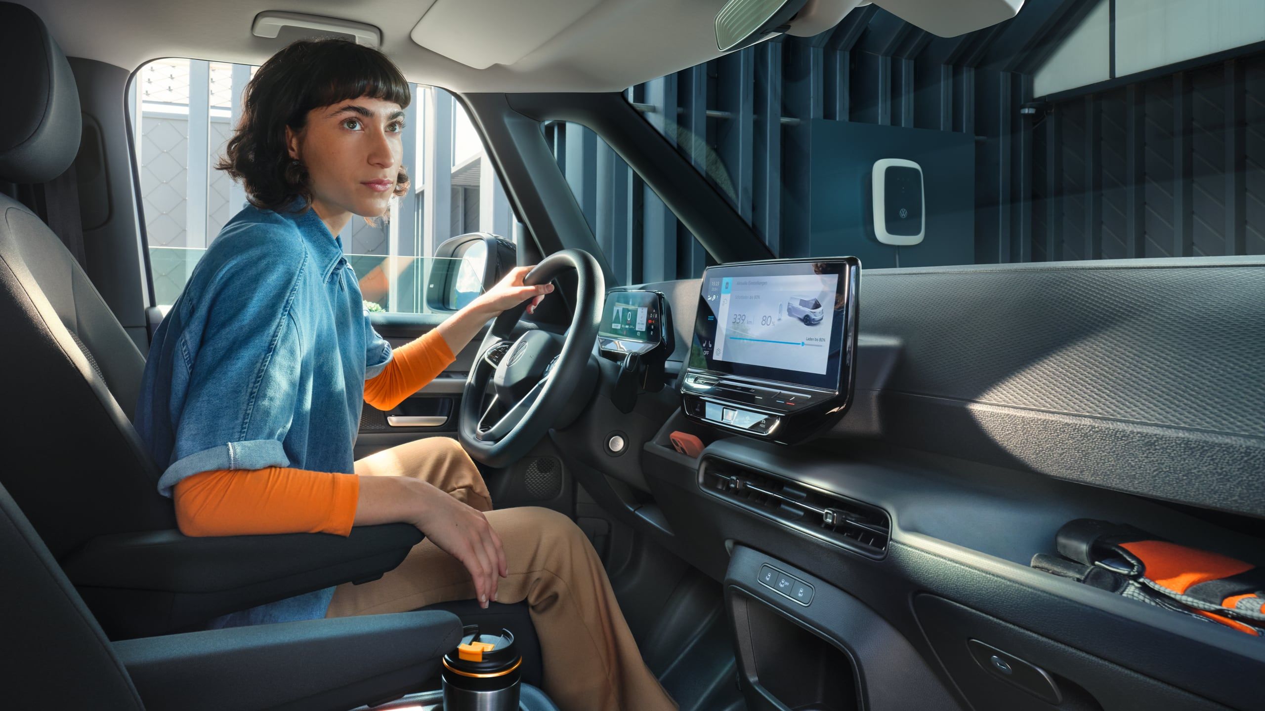 Жена зад волана на електрическия Volkswagen ID. Buzz Cargo по време на зареждане