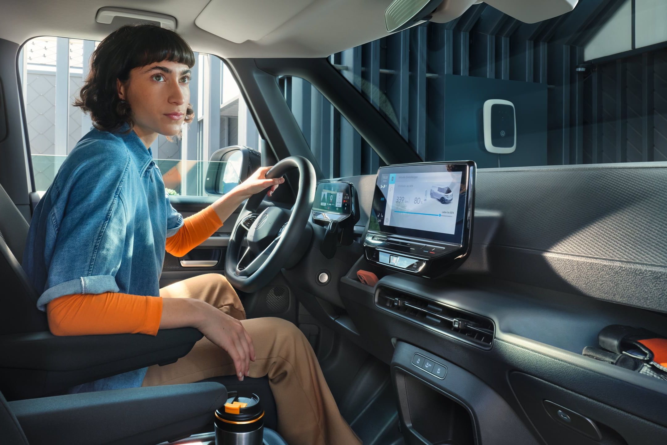 Жена зад волана на електрическия Volkswagen ID. Buzz Cargo по време на зареждане