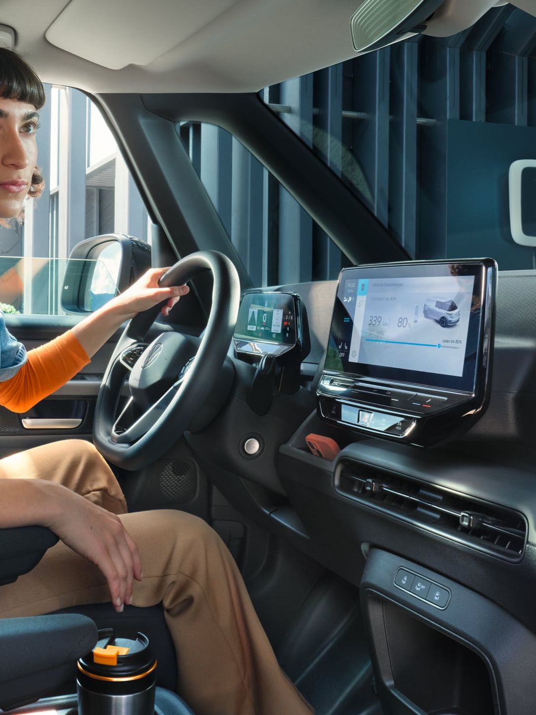 Жена зад волана на електрическия Volkswagen ID. Buzz Cargo по време на зареждане