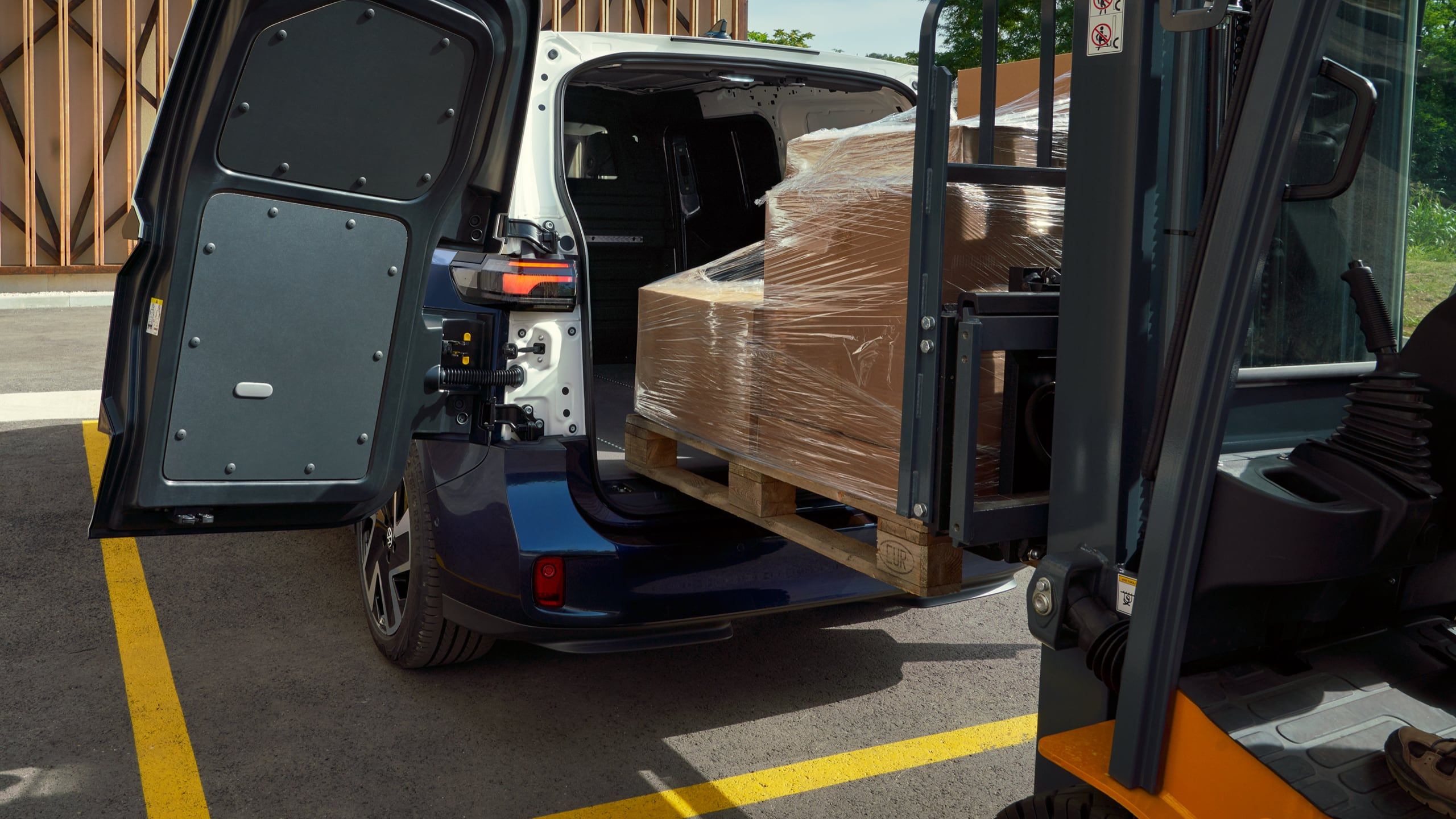 Натоварване на палет с мотокар в багажното отделение на електрическия ID. Buzz Cargo