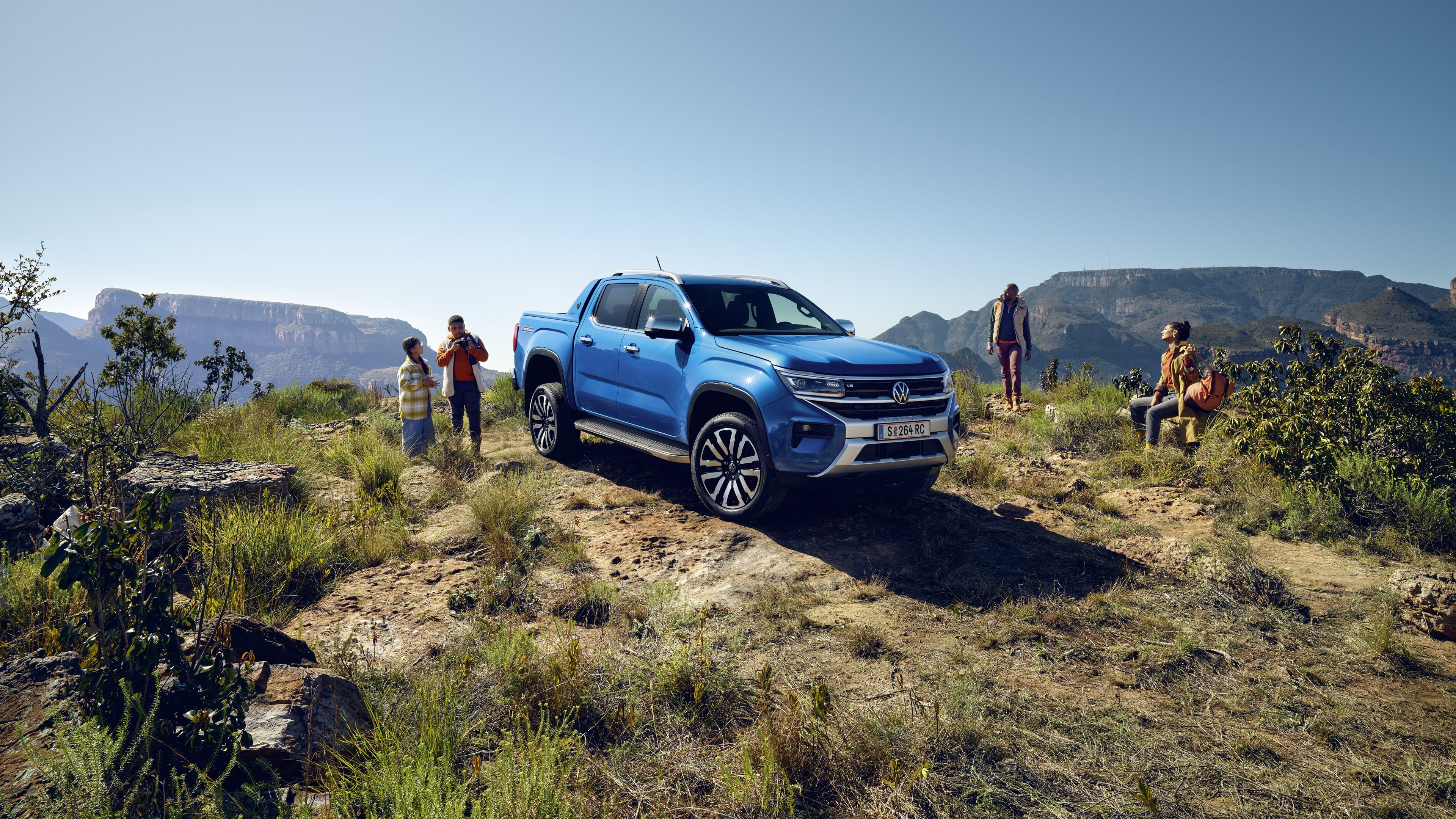 Новият VW Amarok е паркиран на офроуд до семейство