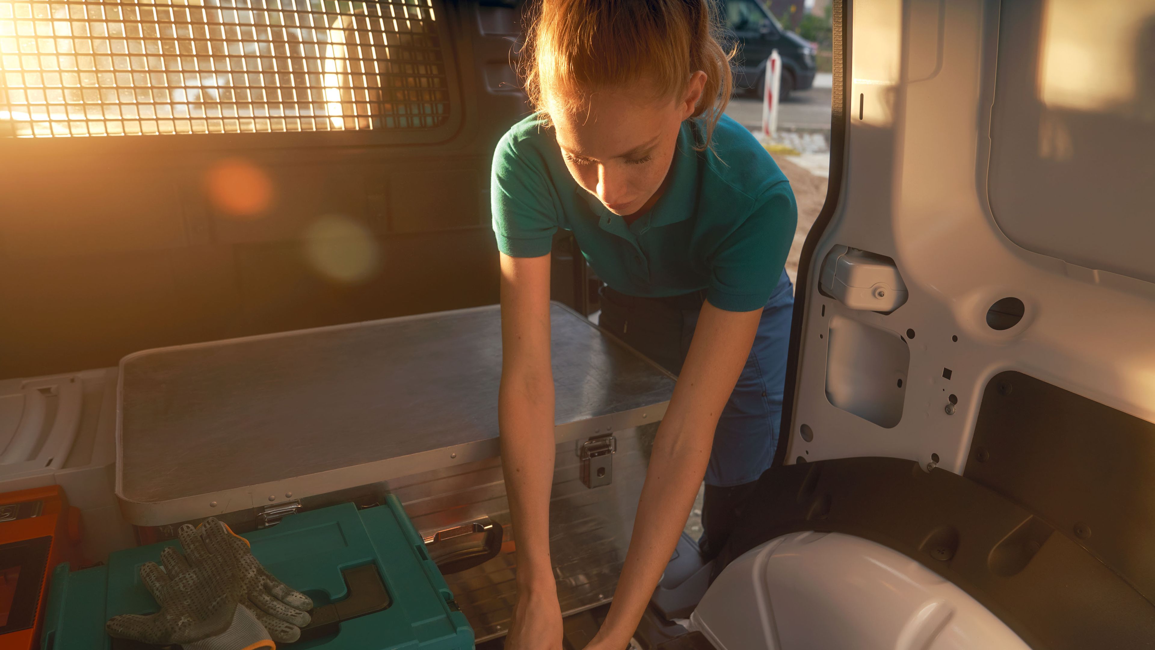 Жена по време на товарене на бял VW Caddy Cargo.