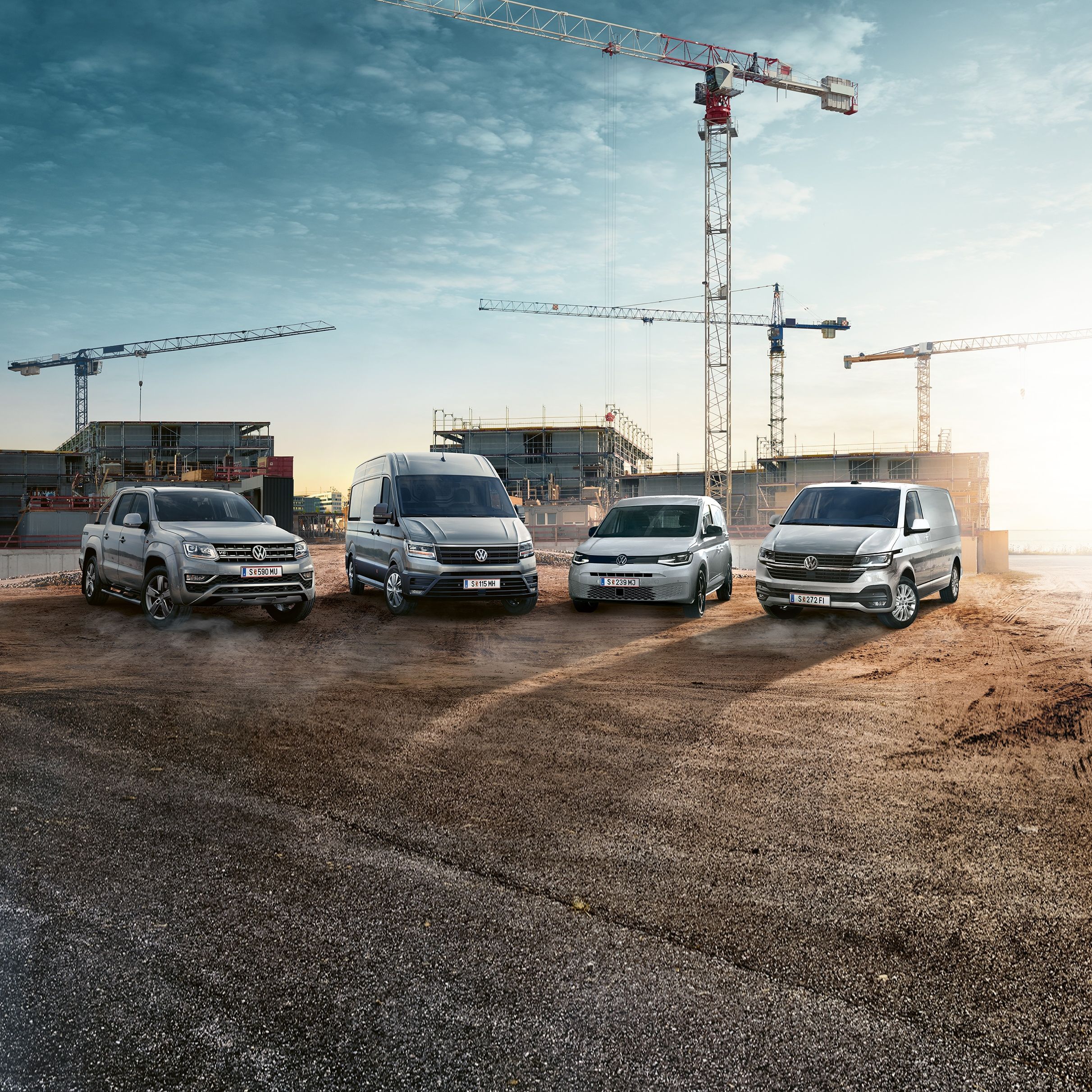 Гамата на Volkswagen лекотоварни автомобили на строителна площадка с кранове на заден план.