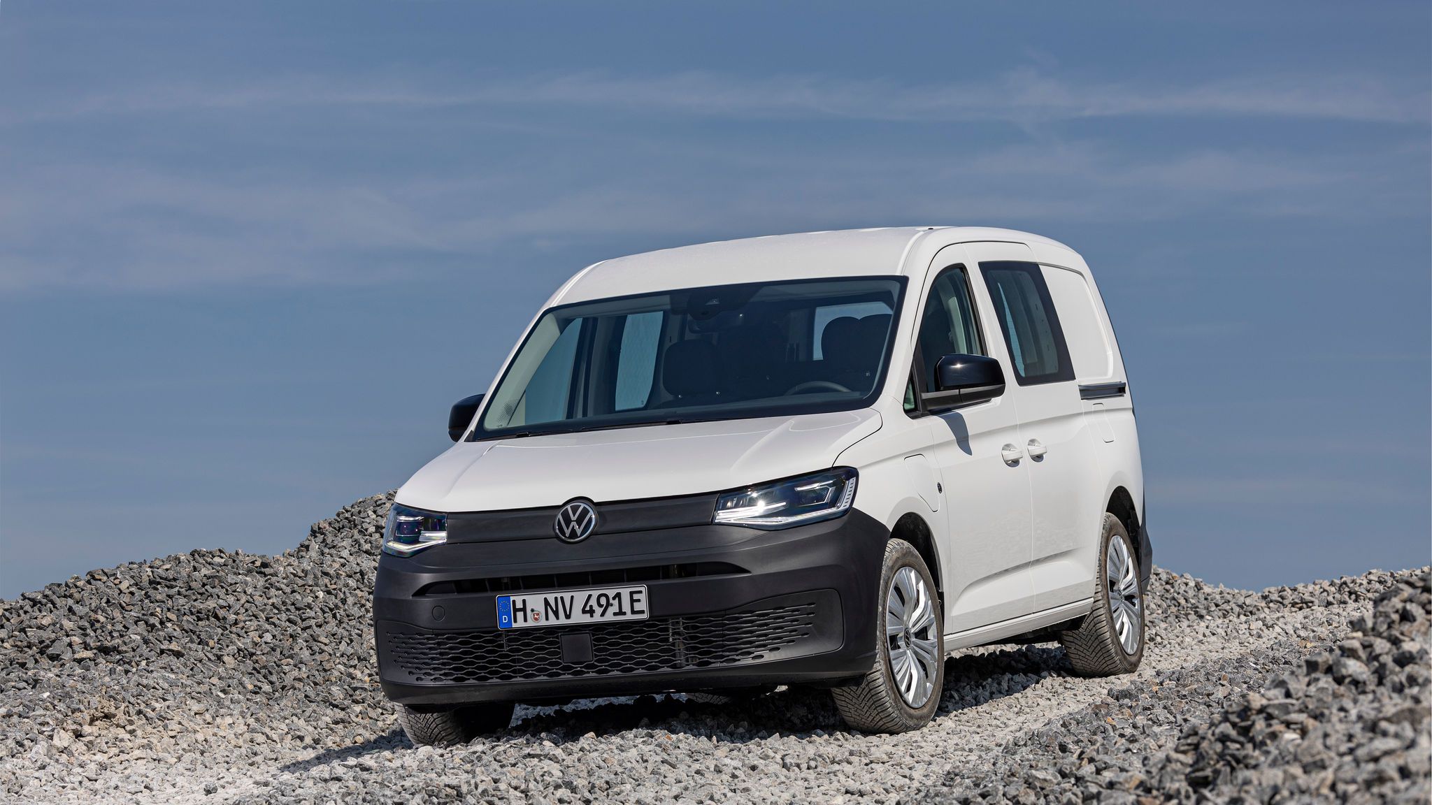 Volkswagen Caddy Cargo в бяло – снимка на лекотоварен модел, заснет на чакъл, подчертаваща издръжливостта му на различни повърхности