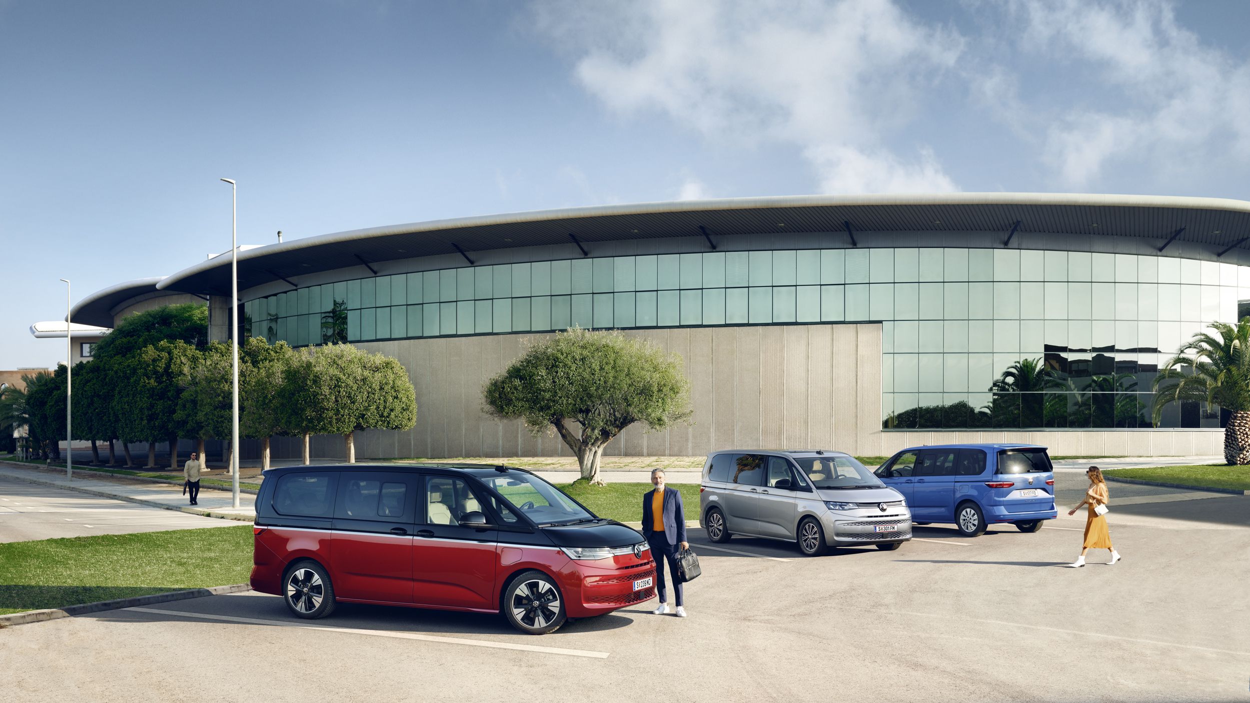 Drei unterschiedliche Varianten des VW Multivan T7 2021 stehen auf einem Parkplatz.
