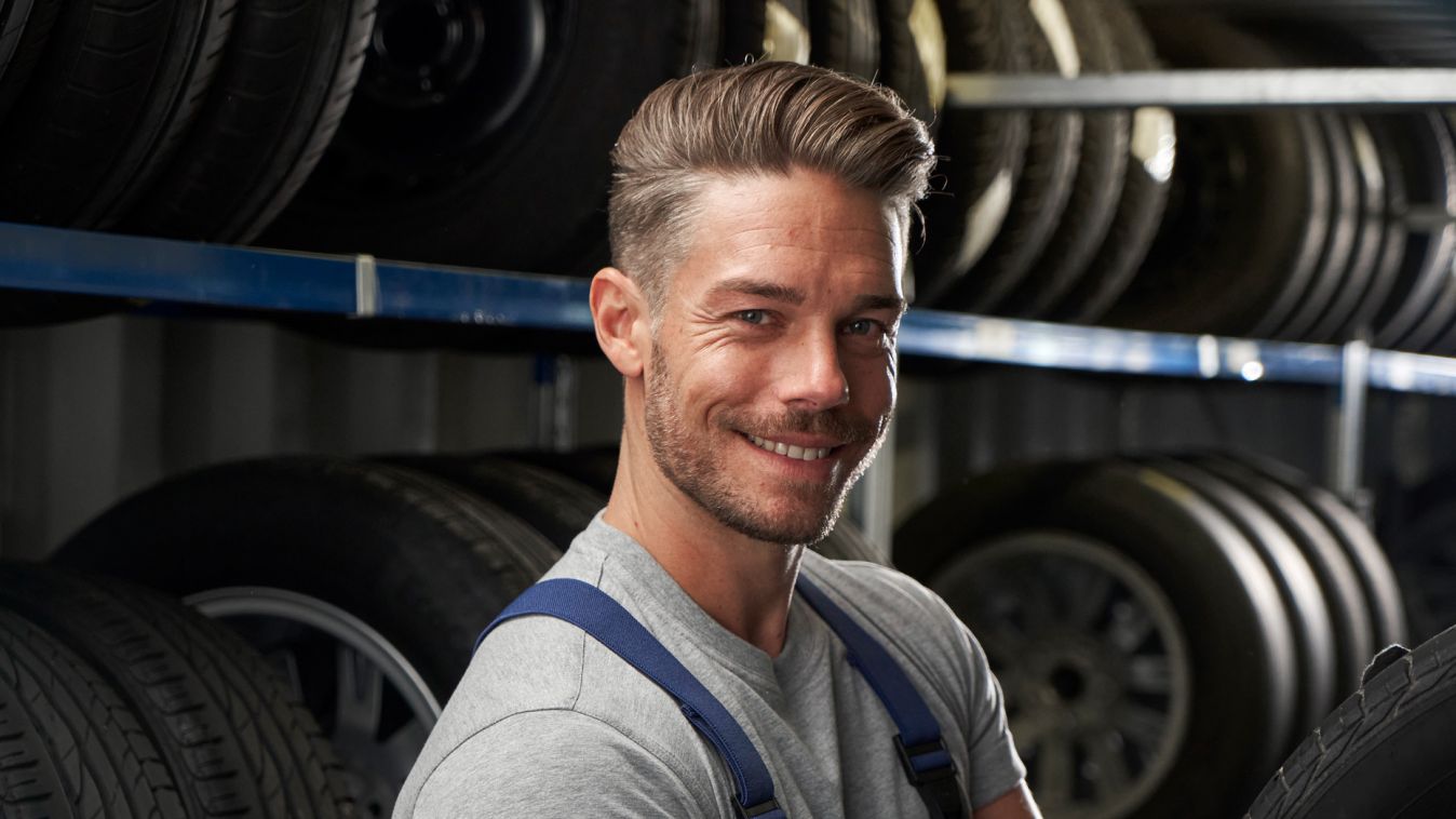 Ein Volkswagen Service Techniker schlichtet Winterkompletträder in ein Regal