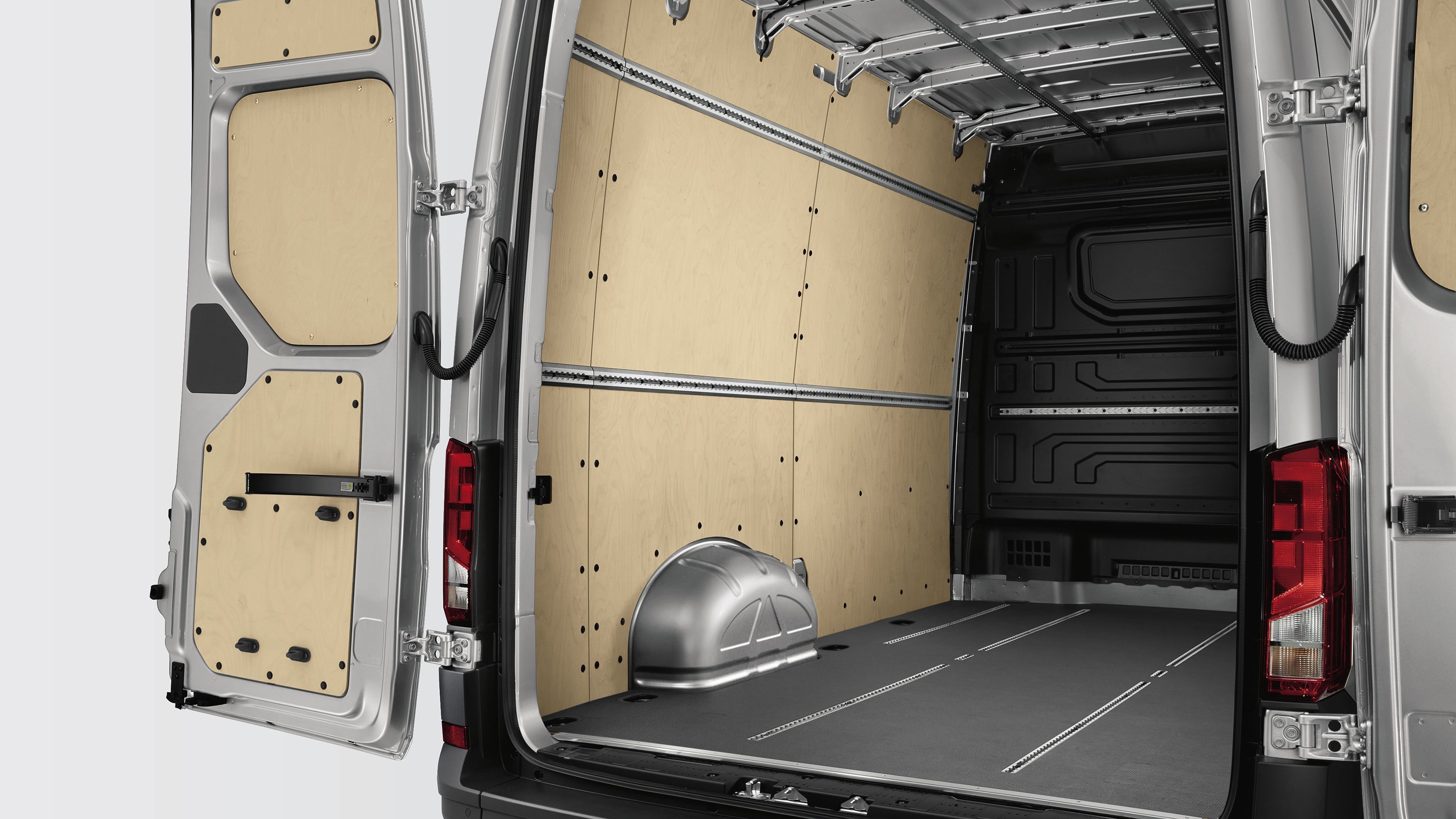 Заден изглед към празно товарно пространство на Volkswagen Crafter с дървена облицовка и метален под.