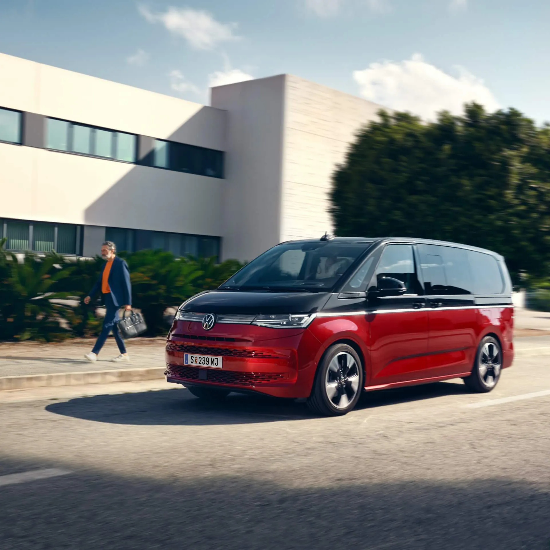 Новият Volkswagen Multivan в червено-черна двуцветна комбинация на улица