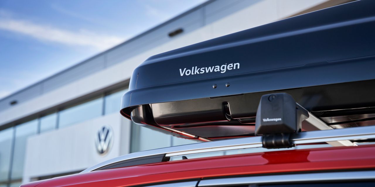 Eine schwarze Dachbox mit Volkswagen Schriftzug am Dach eines Volkswagen