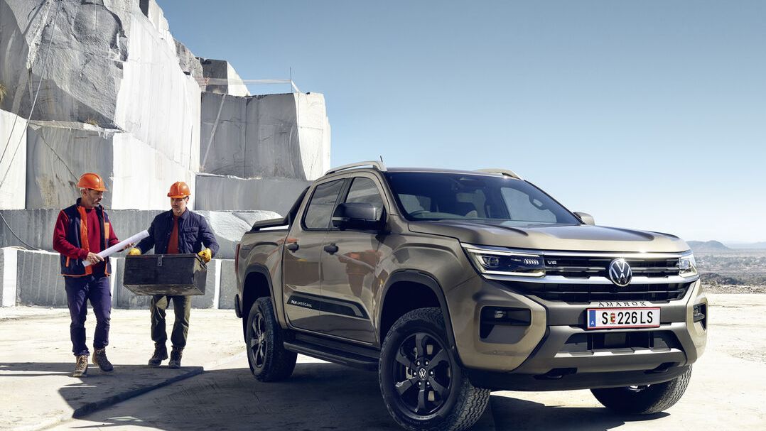VW Amarok с ремарке за коне и жена стои до него на кон.