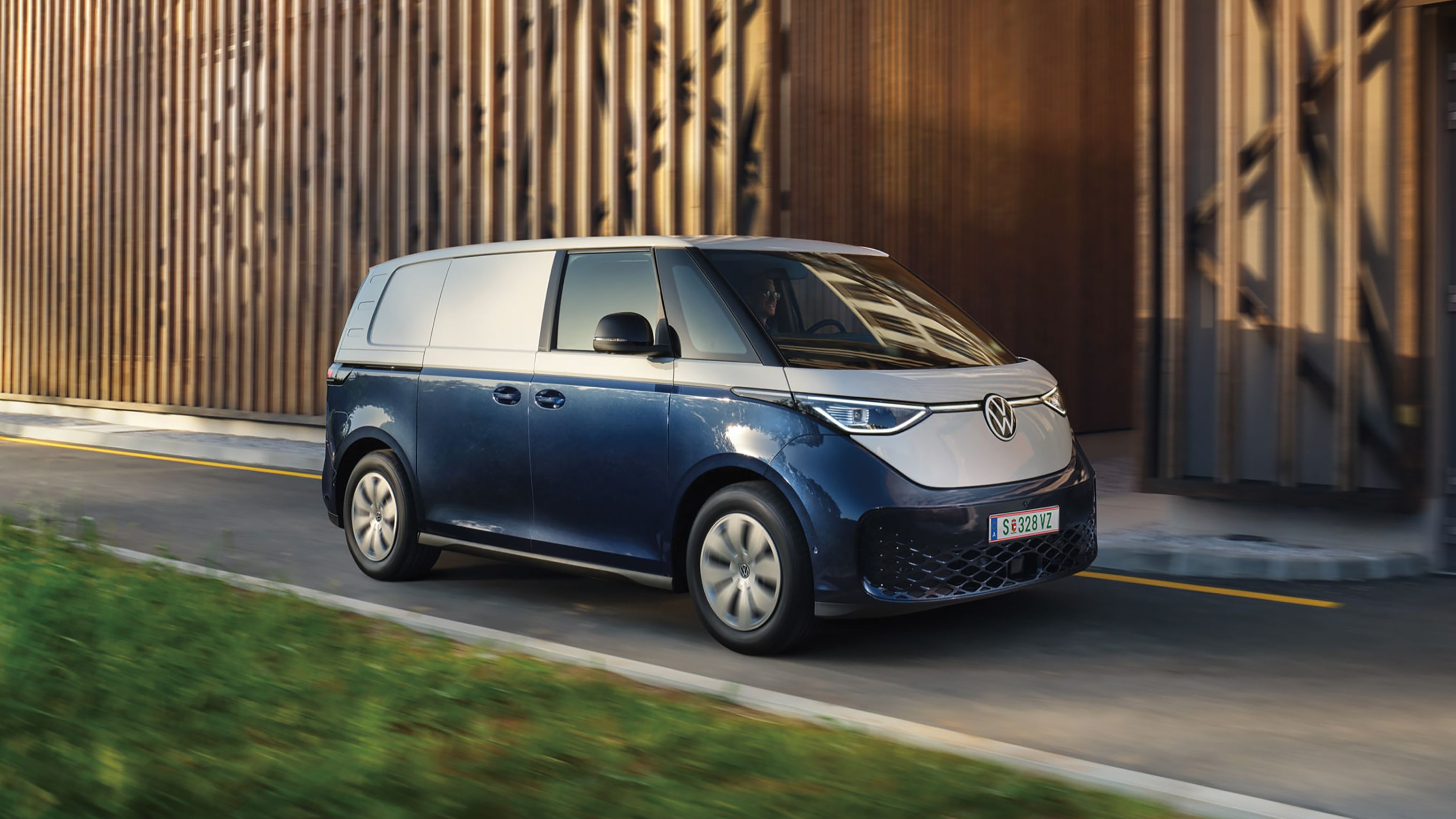 Volkswagen ID. Buzz Cargo в движение пред модерна индустриална сграда