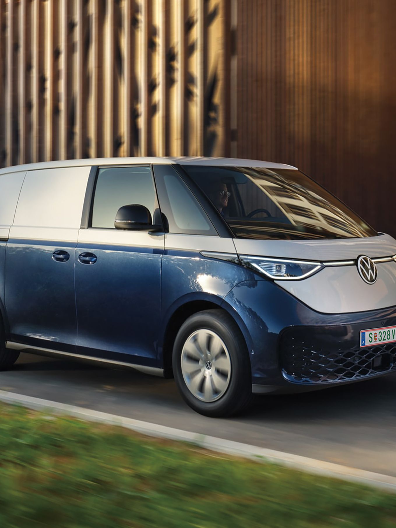 Volkswagen ID. Buzz Cargo в движение пред модерна индустриална сграда