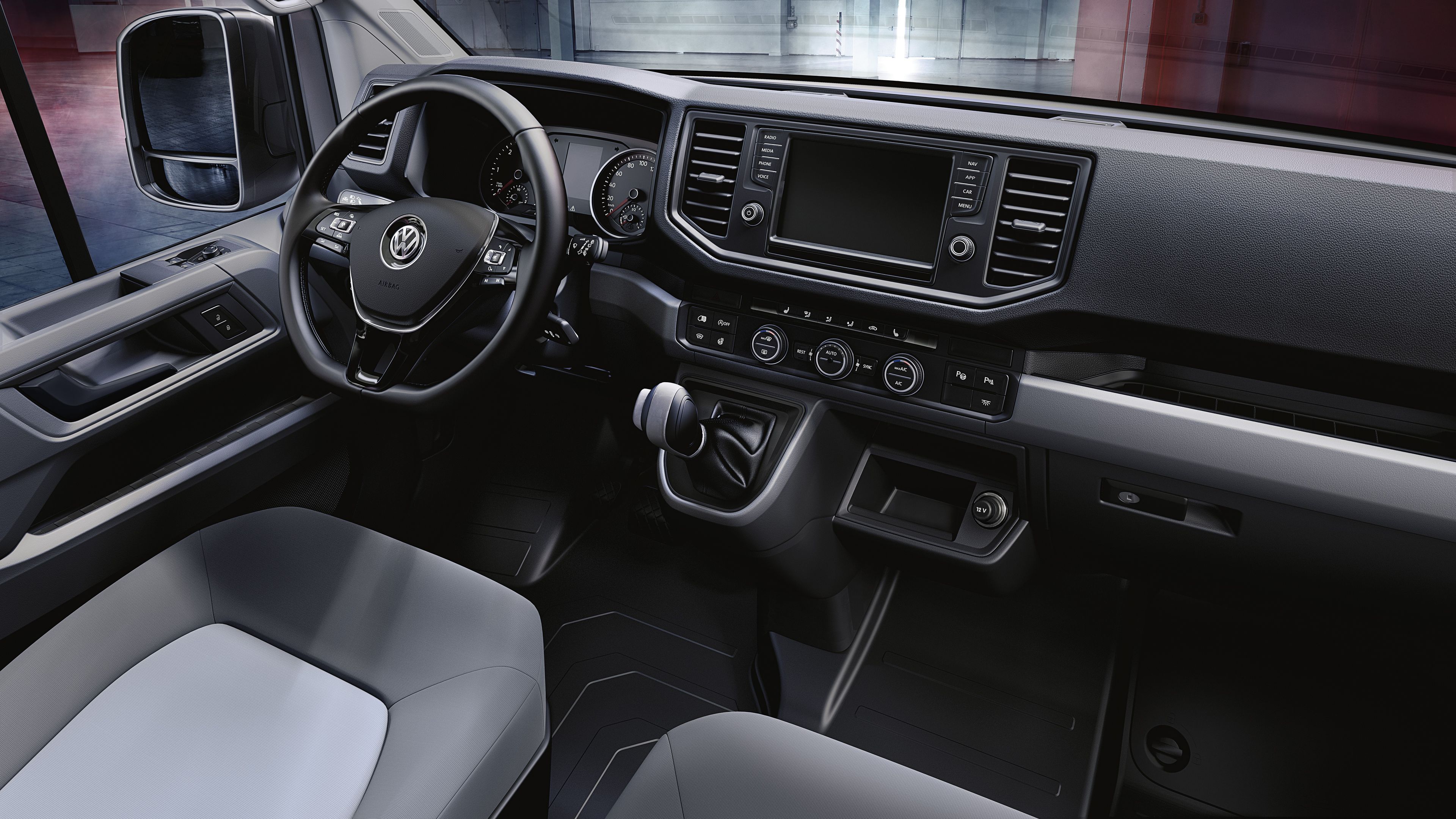 Поглед в кабината на водача на Volkswagen лекотоварен автомобил Crafter с многобройни отделения и поставки за вещи.