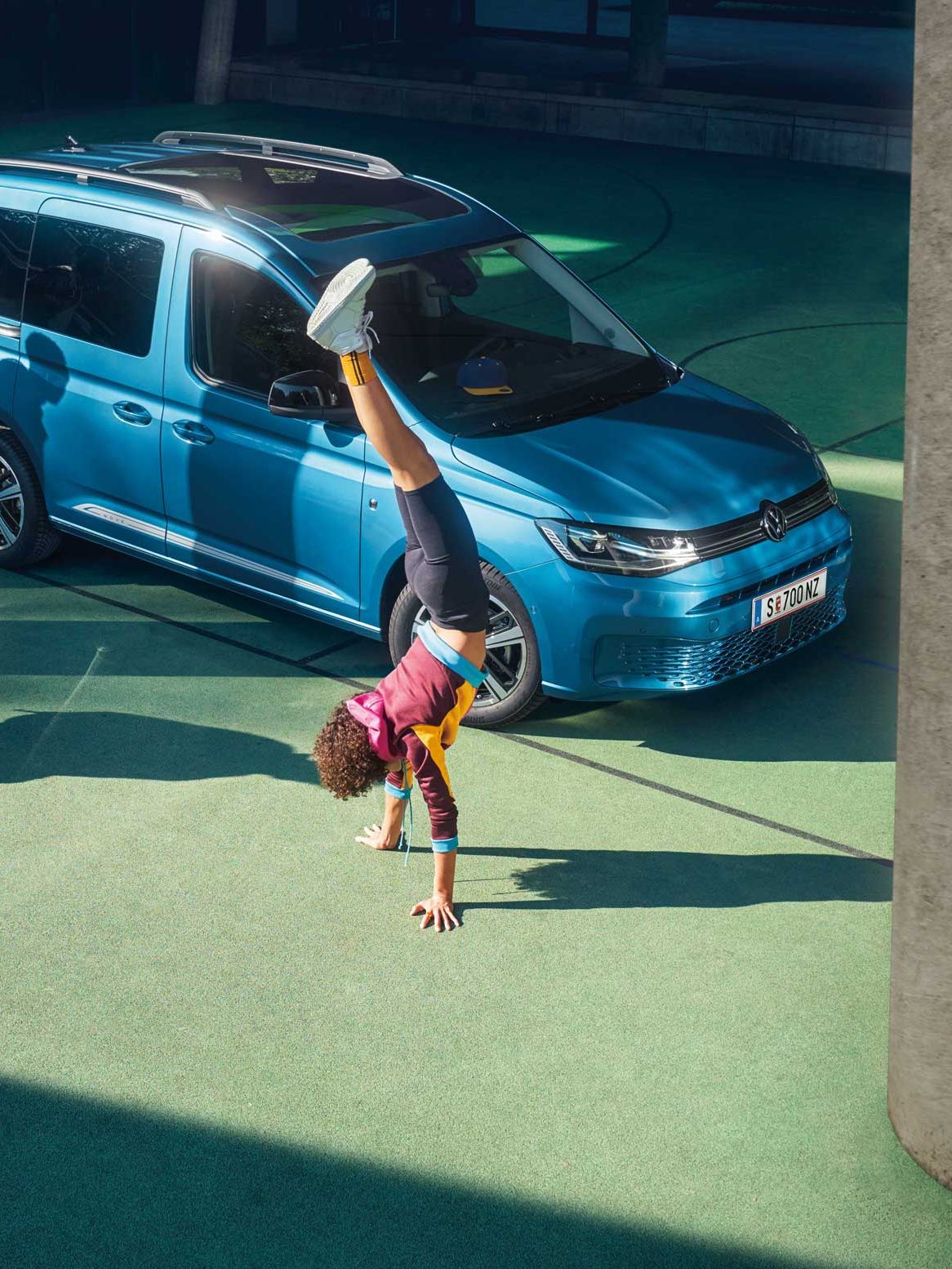 Kinder spielen vor einem VW Caddy