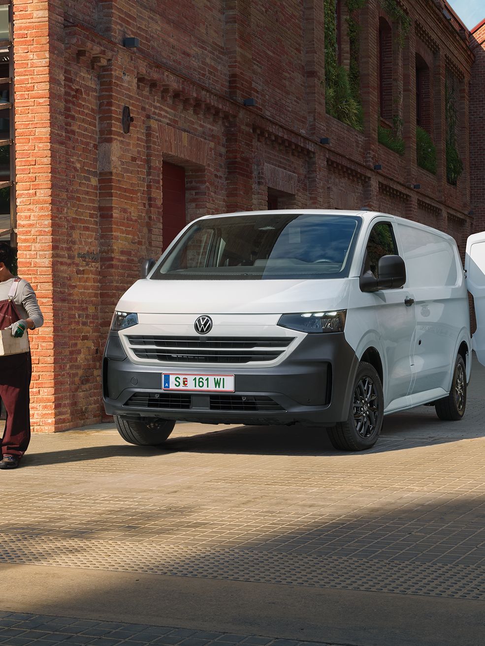 Volkswagen Transporter доставя продукти пред ресторант, докато служители приемат пратката.