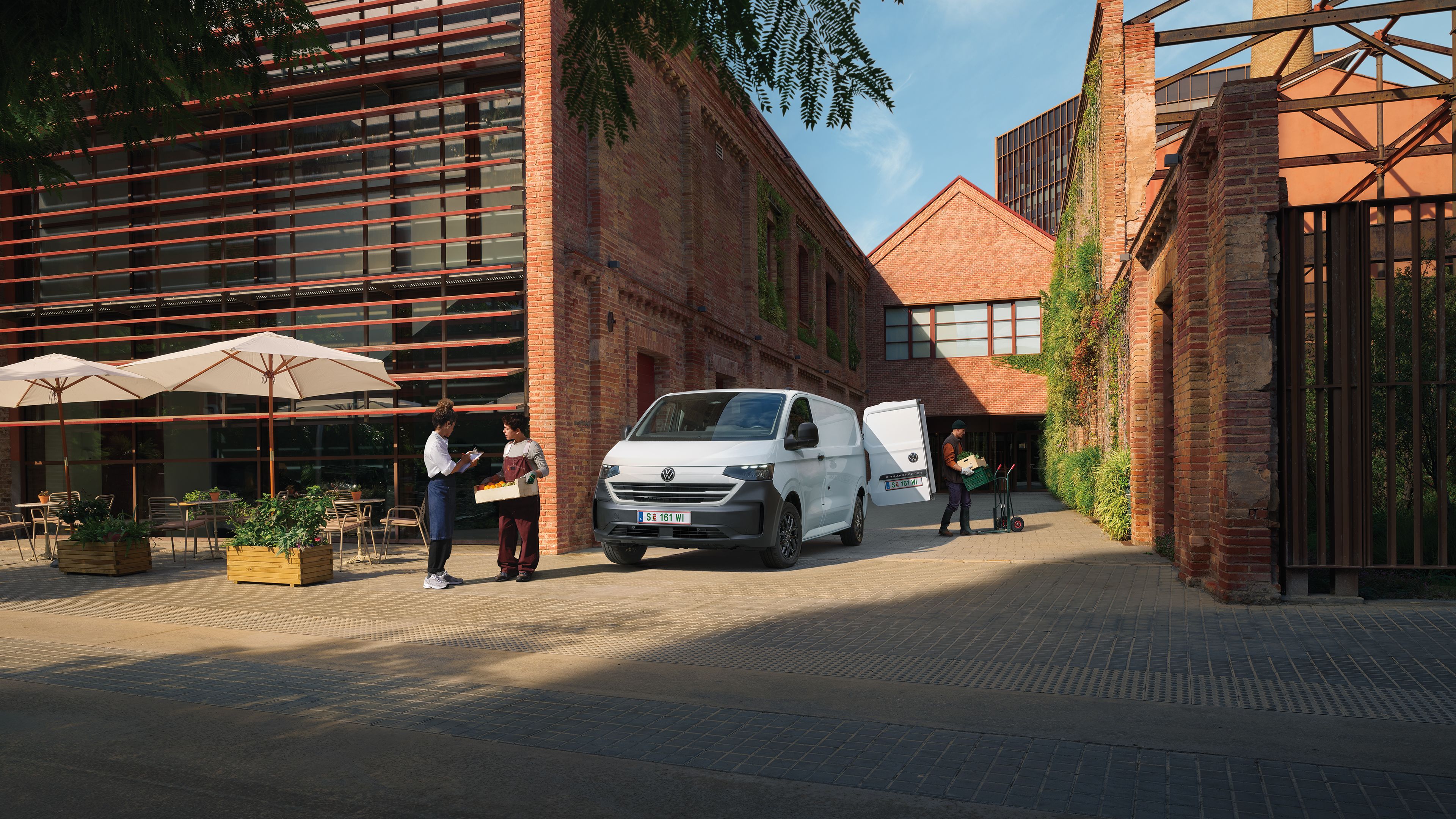 Volkswagen Transporter доставя продукти пред ресторант, докато служители приемат пратката.