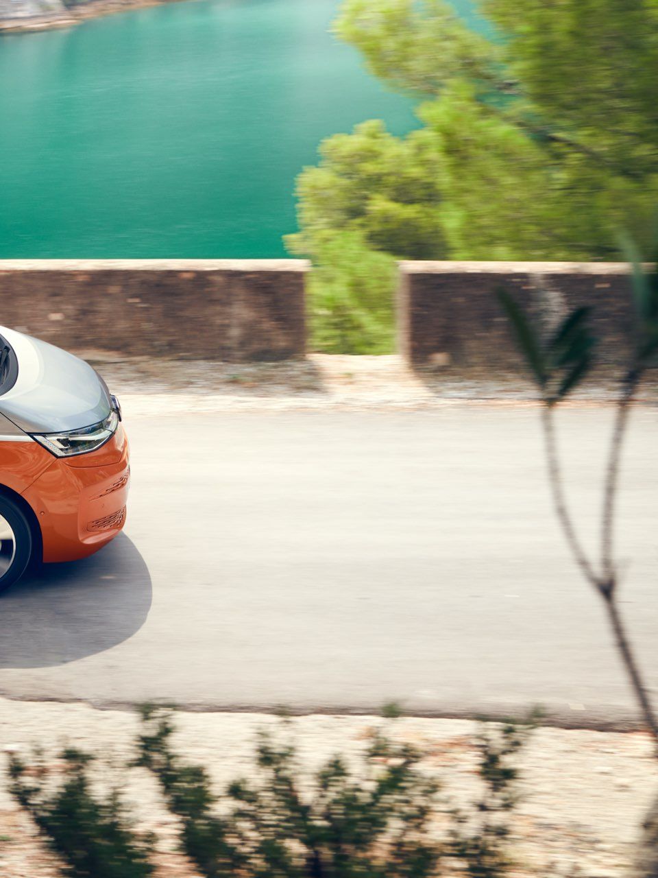 Der neue VW Multivan Energetic T7 2021 fährt auf einer Straße vor dem Meer.
