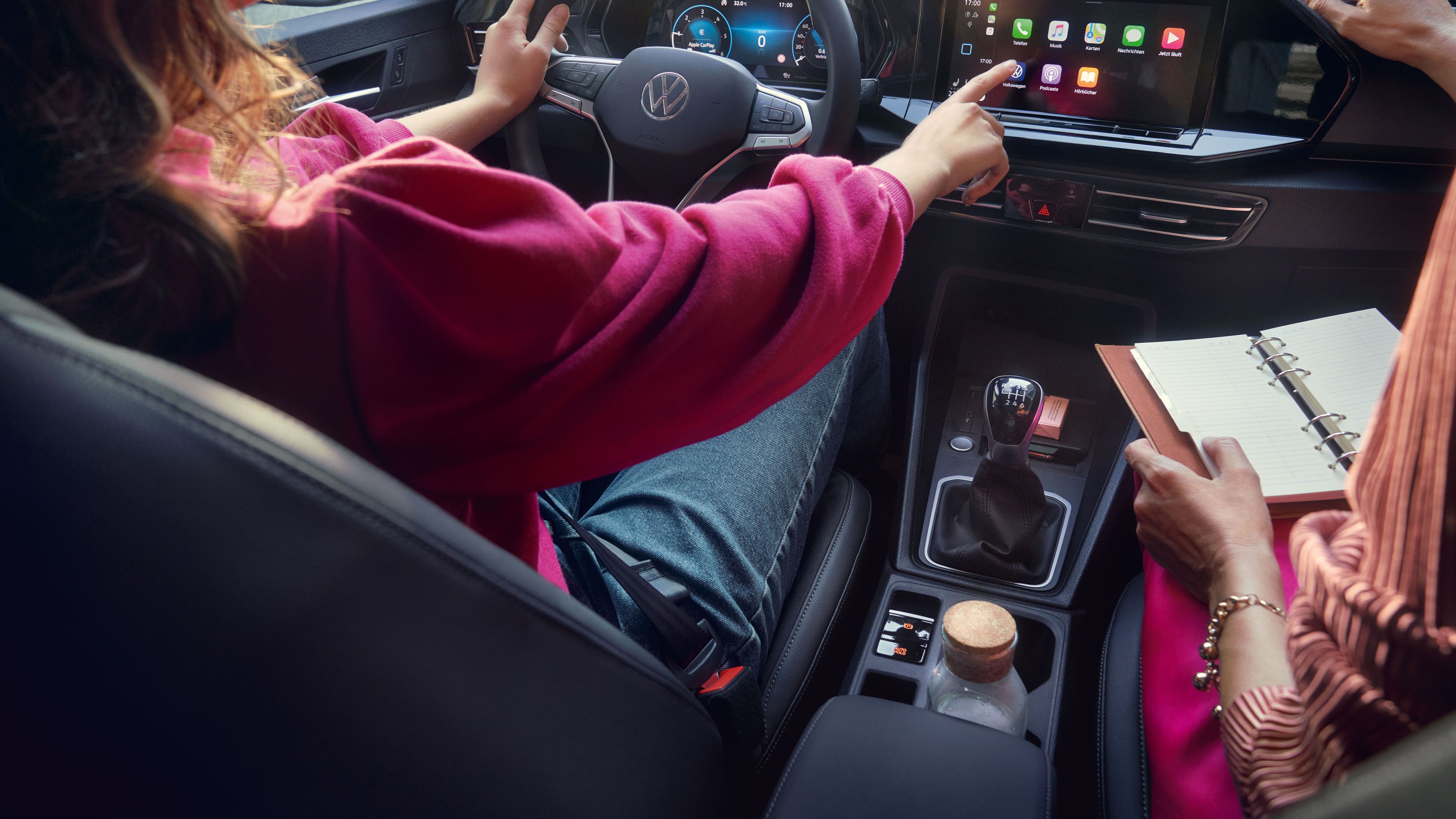 Две жени седят във VW Caddy и използват дигиталното табло.