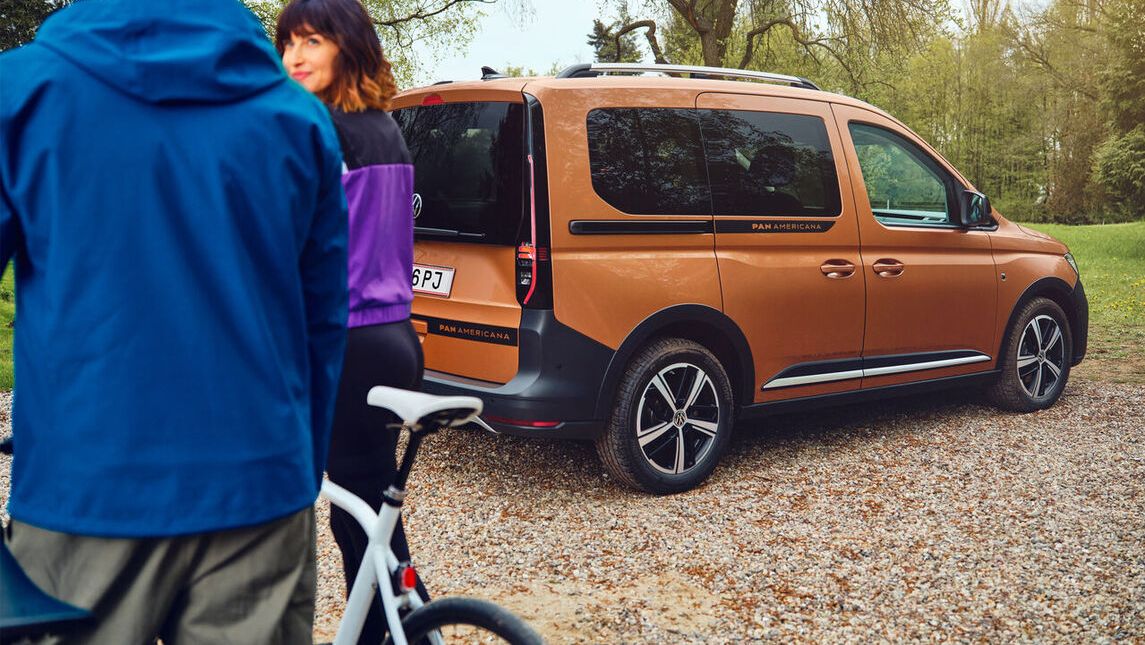 VW Caddy Alltrack обграден от дървета и планини