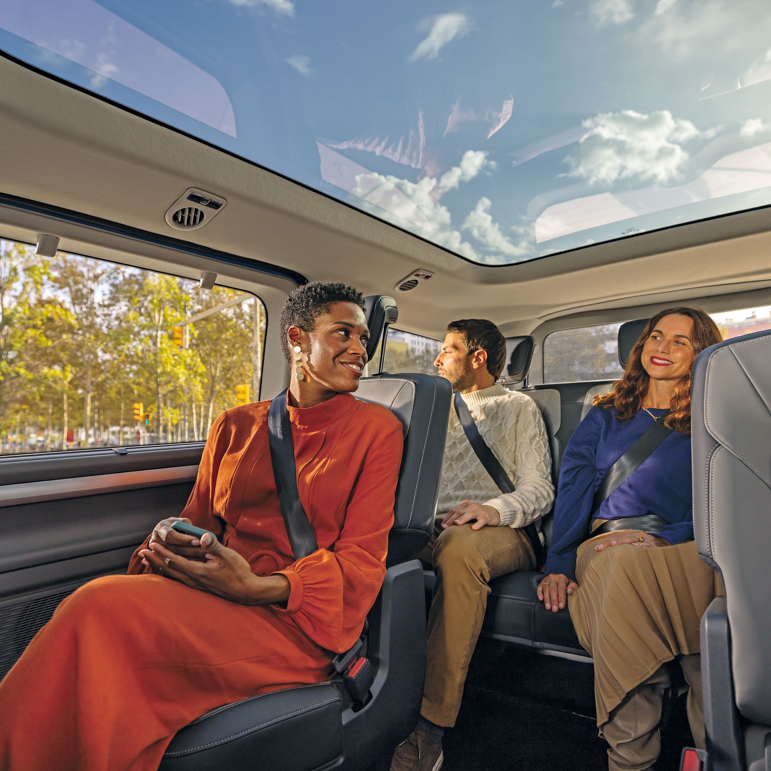 Пътници в новия Volkswagen Caravelle се наслаждават на просторното купе с панорамен покрив