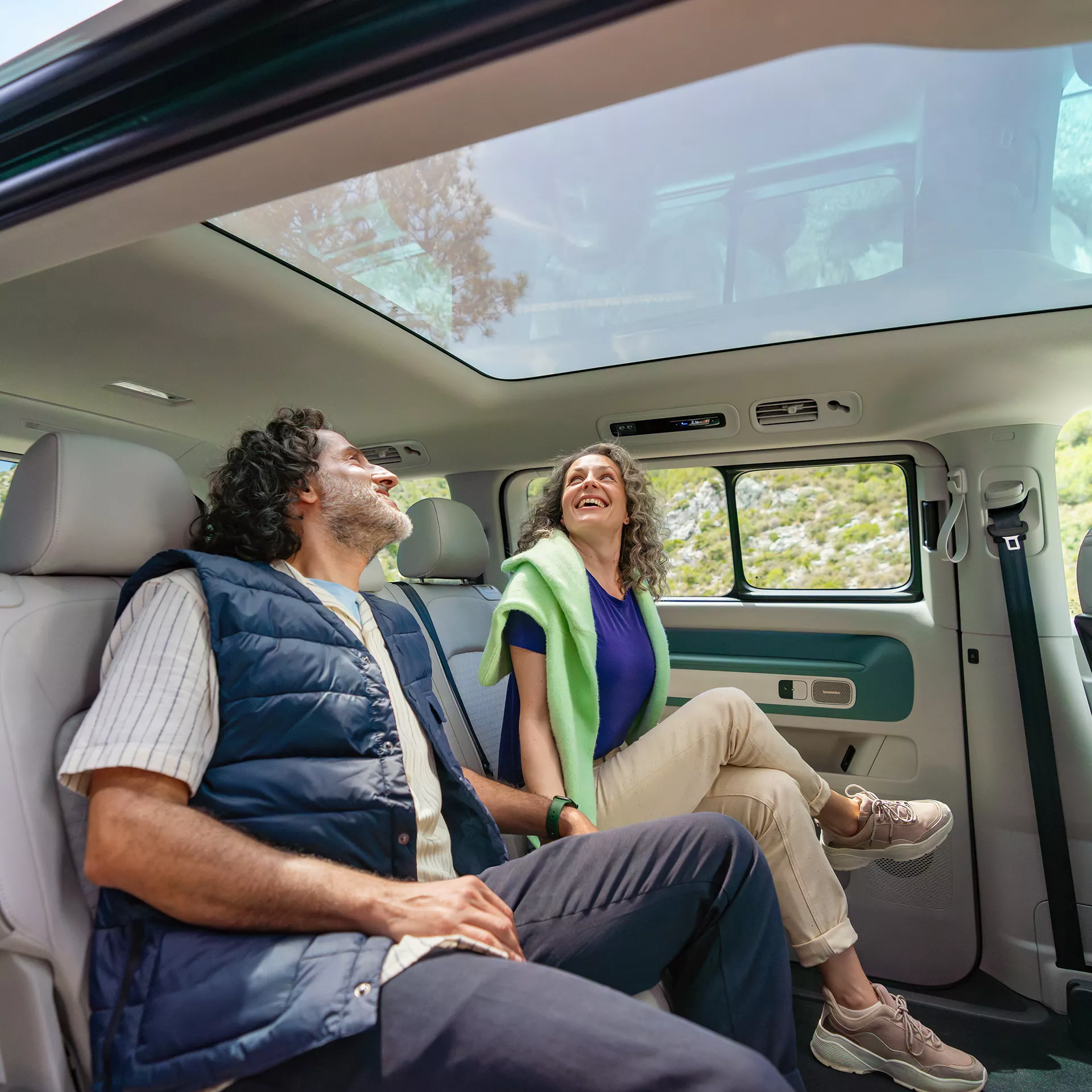  Пътници се наслаждават на светлия интериор с панорамен стъклен покрив във Volkswagen ID. Buzz.