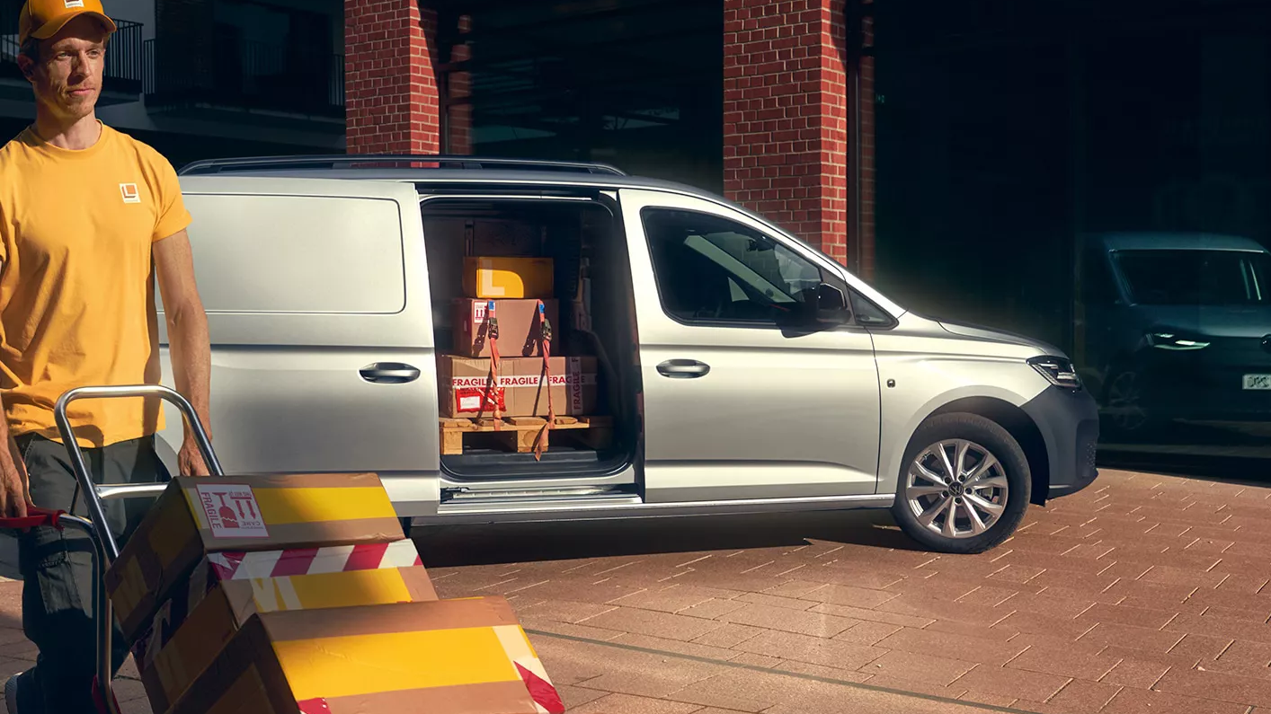 Mann entlädt einen silbernen Caddy Cargo