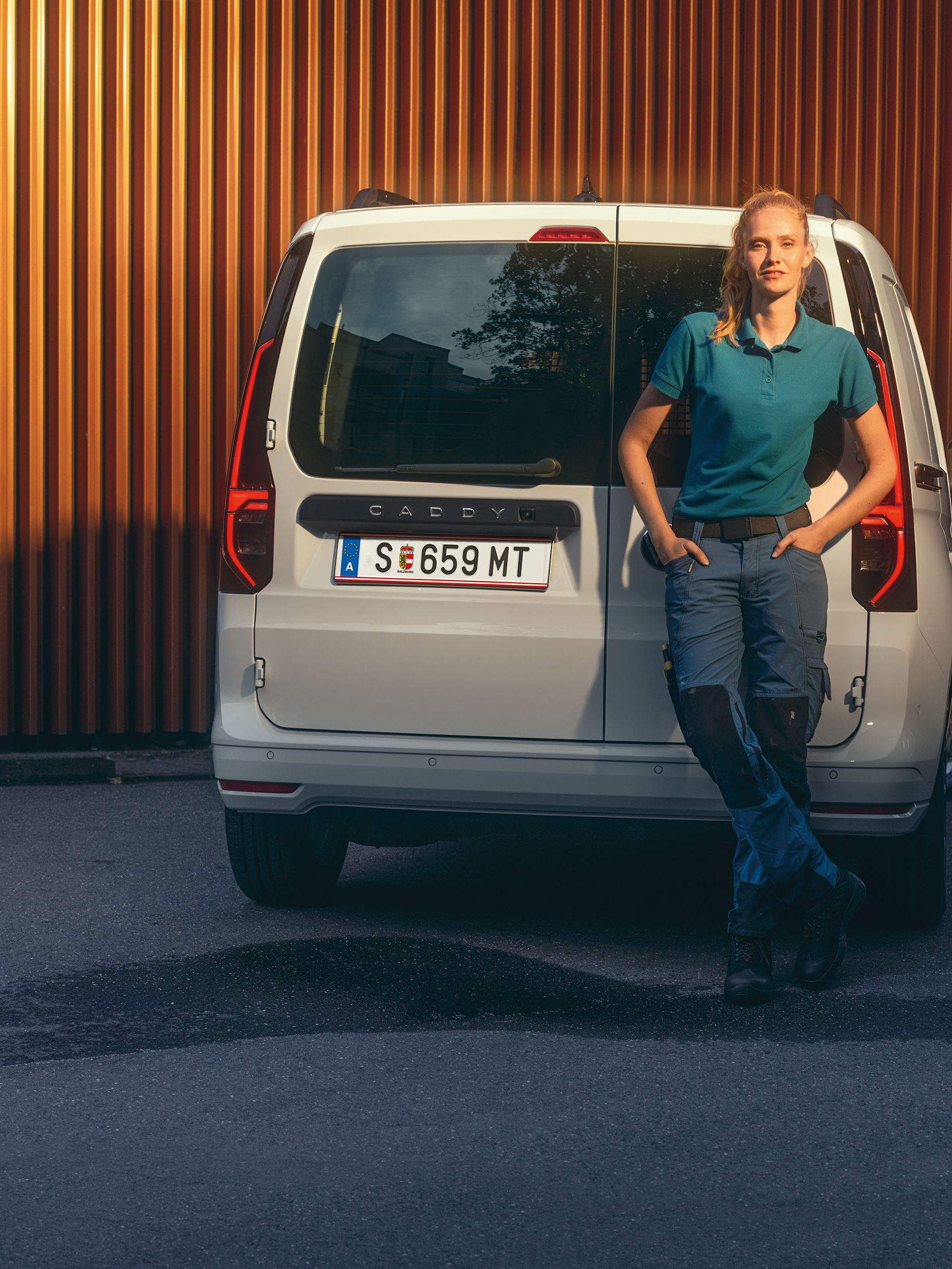 Бял VW Caddy Cargo на улицата, а пред него стои жена