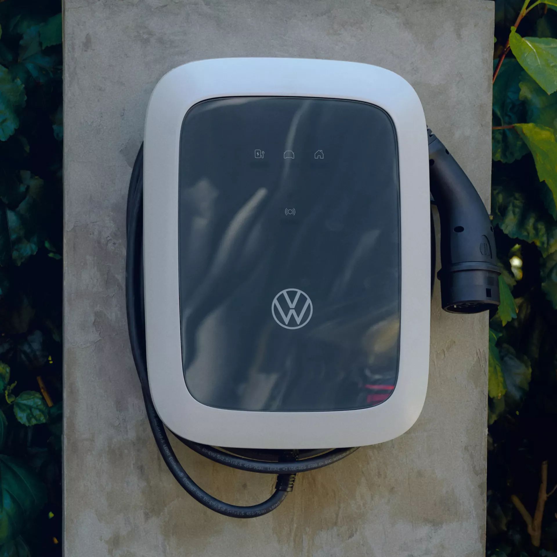 Зарядна станция за електромобили Volkswagen, монтирана на външна стена.